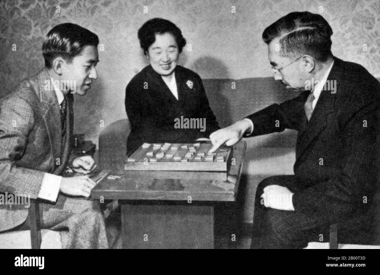Japan: Die kaiserliche Familie spielt ein Brettspiel. Informelles Bild der kaiserlichen Familie, die ein Brettspiel spielt (1950er Jahre). Kronprinz Akihito links, Kaiserin Kojun Zentrum, Kaiser Hirohito rechts. Hirohito, der Kaiser von Shōwa, (29. April 1901 – 7. Januar 1989), war der 124. Kaiser von Japan gemäß dem traditionellen Orden, der vom 25. Dezember 1926 bis zu seinem Tod im Jahr 1989 regierte. Obwohl er außerhalb Japans besser unter seinem persönlichen Namen Hirohito bekannt ist, wird er in Japan nun ausschließlich unter seinem posthumen Namen Kaiser Shōwa bezeichnet. Stockfoto