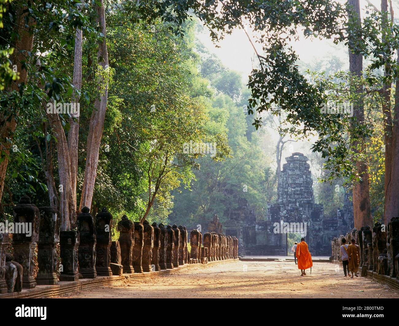 Kambodscha: Ein Mönch geht in Richtung der westlichen Gopura, Preah Khan, Angkor. Preah Khan (Tempel des Heiligen Schwertes) wurde im späten 12. Jahrhundert (1191) von Jayavarman VII. Erbaut und liegt nördlich von Angkor Thom. Der Tempel wurde auf dem Aufstellungsort von Jayavarman VII Sieg über dem eindringenden Chams 1191 errichtet. Es war das Zentrum einer bedeutenden Organisation mit fast 100,000 Beamten und Bediensteten. Es diente als buddhistische Universität zu einer Zeit. Die primäre Gottheit des Tempels ist der boddhisatva Avalokiteshvara in Form von Jayavarmans Vater. Stockfoto