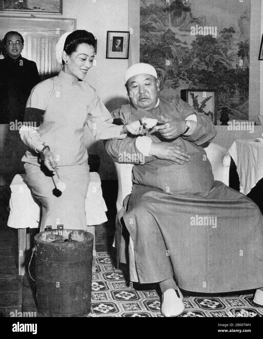 China: Der chinesische muslimische Kriegsherr Ma Hongkui (1892-1970), der den Ruf hatte, Ehefrauen und Eis zu mögen, wurde von seiner vierten und einflussreichsten Frau, ca. 1948, gefüttert. MA Hongkui (1892–1970) war während der Ära der Republik China ein prominenter Kriegsherr in China und regierte die nordwestliche Provinz Ningxia. Sein Rang war Generalleutnant. Er war ein Schlüsselmitglied der ‘Three Ma’ (manchmal ‘Five Ma’) Clique muslimischer Kriegsherren, die Gansu, Qinghai und Ningxia zwischen etwa 1927 und 1949 dominierten. MA Hongkui hatte einen Ruf als guter, aber brutaler General, der gut gegen Japan kämpfte. Stockfoto
