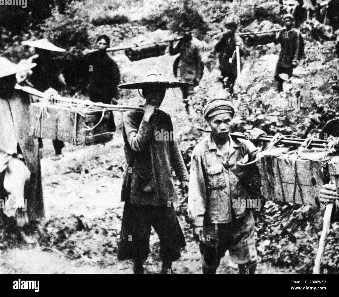 Laos: Laotische und vietnamesische Träger transportieren Nachschub südlich entlang des Ho Chi Minh Trails, um den Aufstand im Süden zu versorgen, c. 1963. Der Ho Chi Minh Trail war ein logistisches System, das von der Demokratischen Republik Vietnam (Nordvietnam) bis zur Republik Vietnam (Südvietnam) durch die benachbarten Königreiche Laos und Kambodscha verlief. Das System unterstützte während des Vietnamkrieges (1955–1975) die Nationale Befreiungsfront Südvietnams (NLF oder Viet Cong) und die vietnamesische Volksarmee (PAVN), die nordvietnamesische Armee. Stockfoto