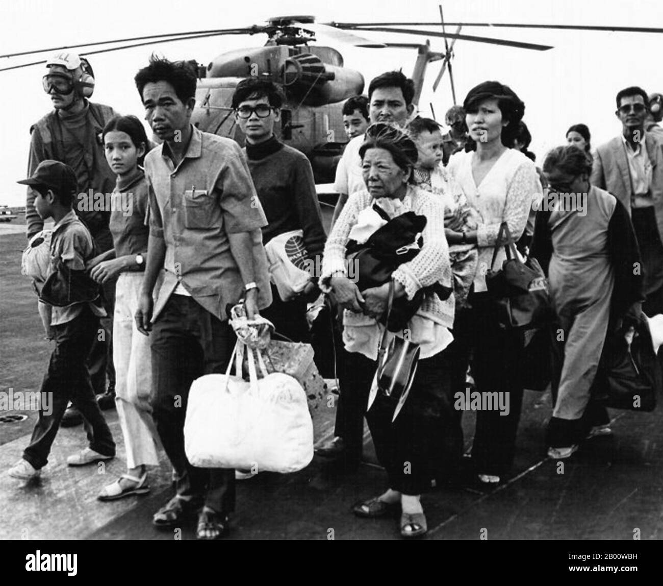 Vietnam: Südvietnamesische Flüchtlinge, die vor der kommunistischen Eroberung von Saigon im Jahr 1975 fliehen, kommen in Camp Foster, Okinawa, Japan an. Südvietnamesische Flüchtlinge laufen über ein US-Navy-Schiff. Operation Frequent Wind, der letzte Betrieb in Saigon, begann am 29. April 1975. Während einer fast ständigen Explosion von Explosionen luden die Marines amerikanische und vietnamesische Zivilisten, die um ihr Leben fürchteten, auf Hubschrauber, die sie zu wartenden Flugzeugträgern brachten. Die Schiffe der Marine brachten sie auf die Philippinen und schließlich nach Camp Pendleton, Kalifornien. (Offizieller US-Navy-Phot im Public Domain-Bereich). Stockfoto