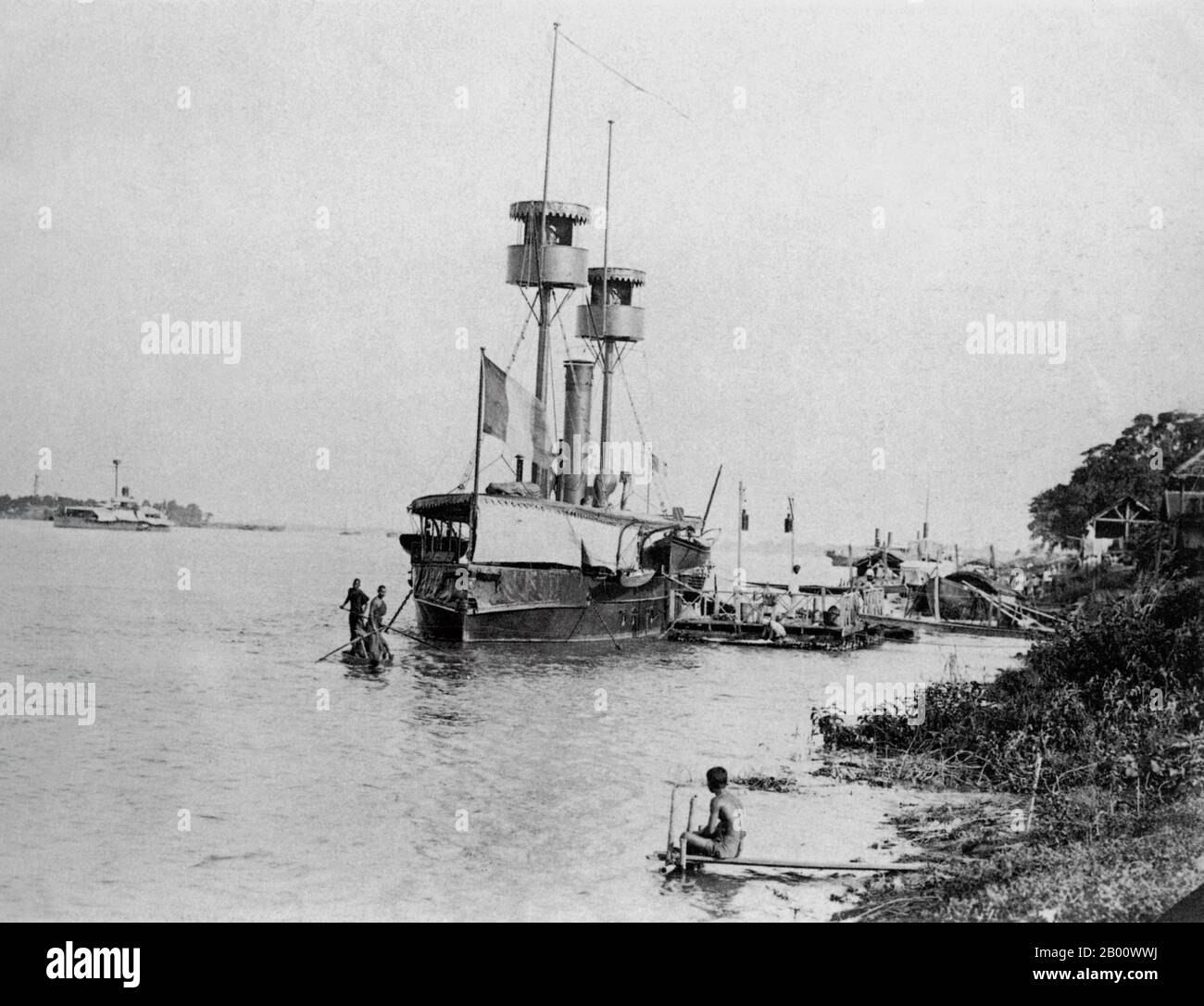 Kambodscha: Ein französisches Kanonenboot, das 1890 auf dem Mekong in Phnom Penh festgemacht wurde. Zwei buddhistische Mönche rudern auf einem Sampan am Bogen vorbei. Am Ufer des Tonle SAP, Mekong und Bassac gelegen, ist Phnom Penh ein idealer Standort für ein Handelszentrum und Hauptstadt. Es ist heute die Heimat von mehr als 2 Millionen der 14 Millionen Einwohner Kambodschas. Phnom Penh wurde zuerst die Hauptstadt von Kambodscha, nachdem Ponhea Yat, der letzte König des Khmer-Reiches, gezwungen wurde, Angkor Thom zu fliehen, nachdem es von der siamesischen Armee im Jahr 1393 erobert wurde. Phnom Penh blieb die königliche Hauptstadt, bis sie 1505 aufgegeben wurde. Stockfoto