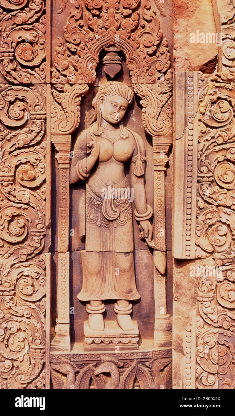 Kambodscha: Devata (Göttliche Nymphe), Banteay Srei (Zitadelle der Frauen), bei Angkor. Banteay Srei (oder Banteay Srey) ist ein kambodschanischer Tempel aus dem 10. Jahrhundert, der dem Hindu-gott Shiva gewidmet ist und im Nordosten der Hauptgruppe von Tempeln in Angkor liegt. Banteay Srei ist weitgehend aus rotem Sandstein gebaut, ein Medium, das sich für die aufwendigen dekorativen Wandschnitzereien eignet, die noch heute zu beobachten sind. Banteay Srei wird manchmal als das "Juwel der Khmer-Kunst" bezeichnet. Stockfoto
