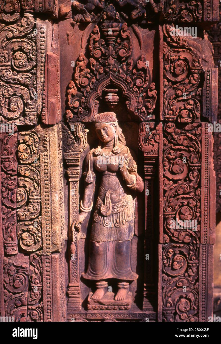 Kambodscha: Devata (Göttliche Nymphe), Banteay Srei (Zitadelle der Frauen), bei Angkor. Banteay Srei (oder Banteay Srey) ist ein kambodschanischer Tempel aus dem 10. Jahrhundert, der dem Hindu-gott Shiva gewidmet ist und im Nordosten der Hauptgruppe von Tempeln in Angkor liegt. Banteay Srei ist weitgehend aus rotem Sandstein gebaut, ein Medium, das sich für die aufwendigen dekorativen Wandschnitzereien eignet, die noch heute zu beobachten sind. Banteay Srei wird manchmal als das "Juwel der Khmer-Kunst" bezeichnet. Stockfoto