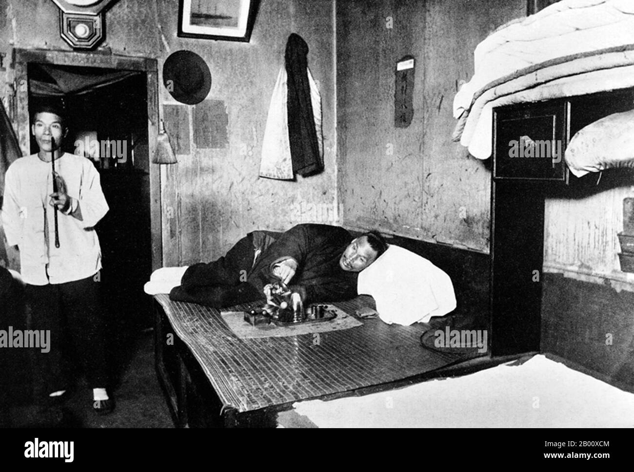 USA: Zwei Chinesen in einer Opiumhöhle in San Francisco, 1890er Jahre. San Franciscos Chinatown war der Hafen der Einreise für frühe hoisanesische und zhongshanesische chinesische Einwanderer aus der Provinz Guangdong im Süden Chinas von den 1850er bis 1900er Jahren. Das Gebiet war die eine geographische Region, die von der Stadtregierung und privaten Besitzern deeded wurde, die chinesischen Personen erlaubte, Wohnungen innerhalb der Stadt zu erben und zu bewohnen. Die Mehrheit dieser chinesischen Ladenbesitzer, Restaurantbesitzer und Angestellten in Chinatown von San Francisco waren überwiegend Hoisanesen und Männer. Stockfoto