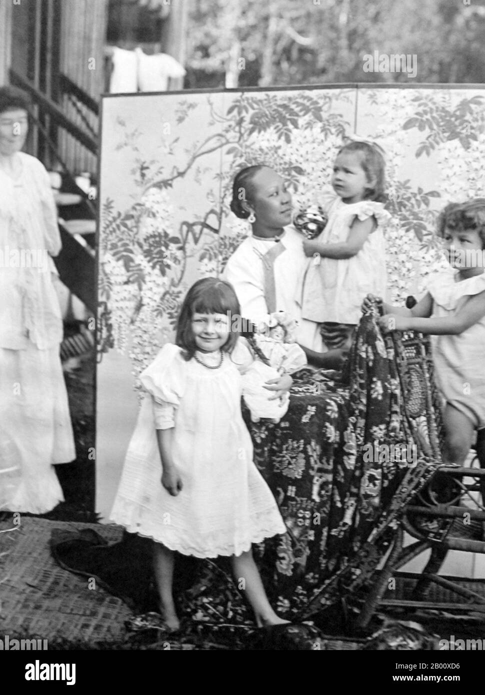 Singapur: Ein Amah posiert mit europäischen Kindern, wie das europäische 'Mem' anschaut, c. 1900. Singapur geriet 1819 unter britischen Einfluss, als die [britische] Ostindien-Kompanie dort mit Genehmigung des Sultanats Johor einen Handelshafen eröffnete. Die Briten erlangten 1824 die Souveränität über die Insel und Singapur wurde 1826 zu einer der britischen Straits-Siedlungen. Im Zweiten Weltkrieg von den Japanern besetzt, erklärte Singapur die Unabhängigkeit und Vereinigte sich 1963 mit anderen ehemaligen britischen Territorien zu Malaysia, obwohl es zwei Jahre später von Malaysia getrennt wurde. Stockfoto