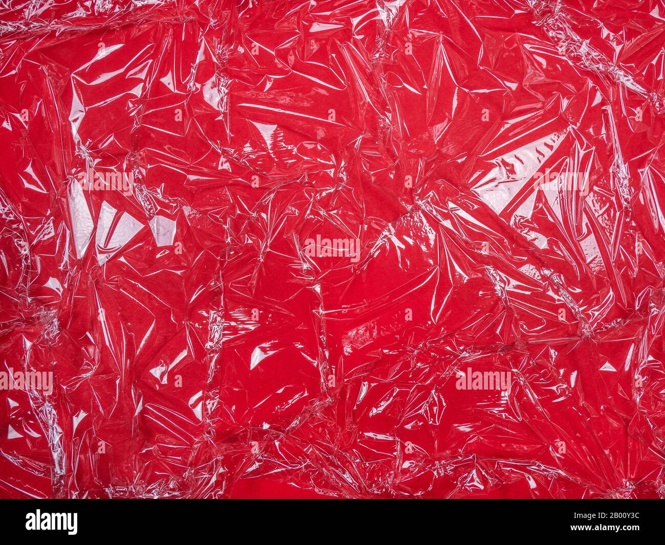 Transparente Kunststofffolie auf rotem Hintergrund Stockfoto