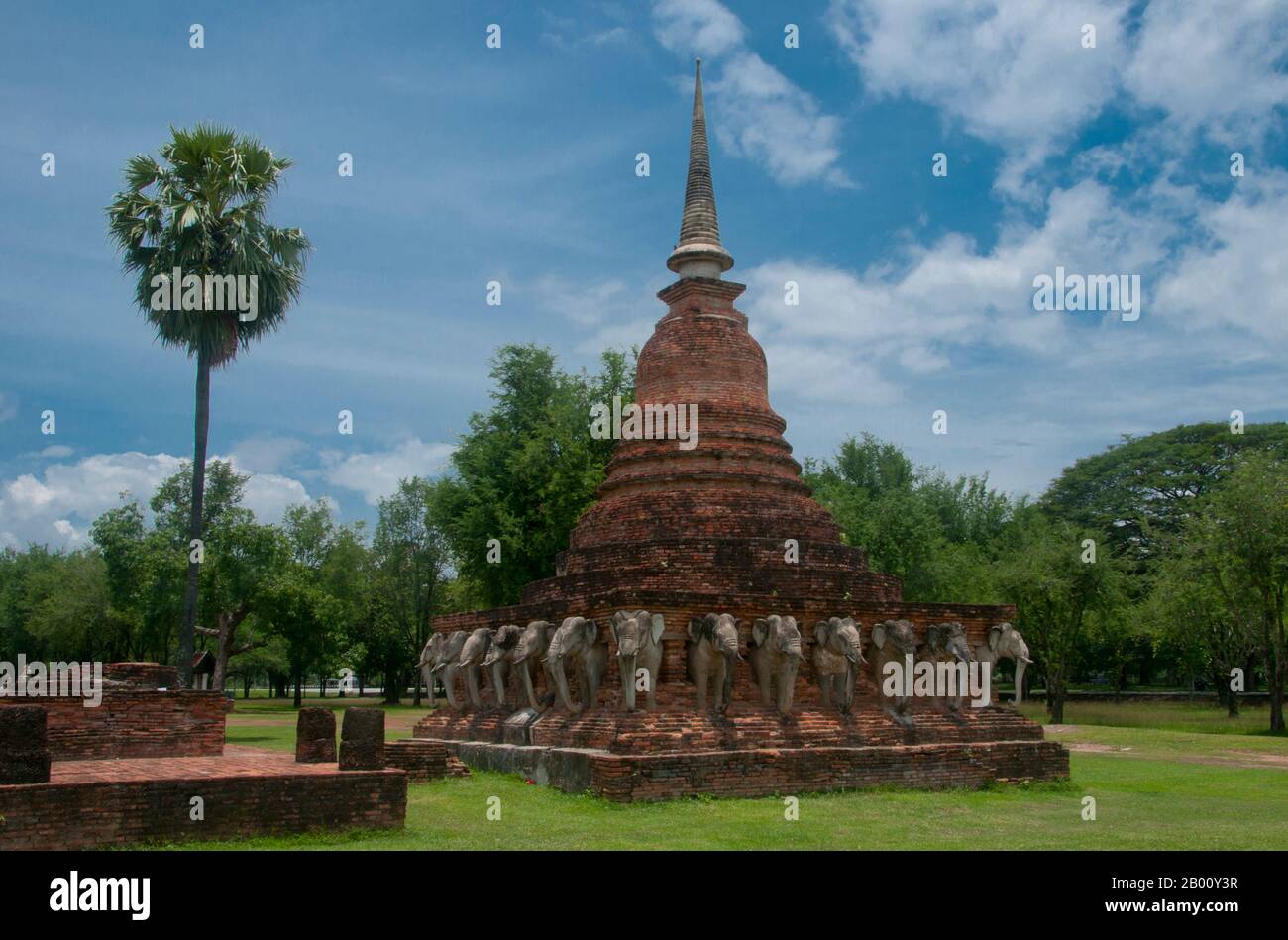 Thailand: Wat Sorasak, Sukhothai Historischer Park. Wat Sorasak wurde im frühen 15. Jahrhundert erbaut und ist bekannt für die 24 Elefanten, die die Basis des Sri Lanka-Stil Chedi umgeben. Sukhothai, was wörtlich "Dawn of Happiness" bedeutet, war die Hauptstadt des Sukhothai-Königreichs und wurde 1238 gegründet. Es war die Hauptstadt des thailändischen Reiches für etwa 140 Jahre. Stockfoto