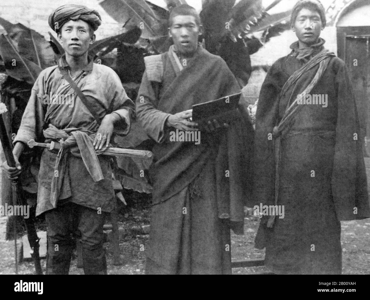 Tibet/China: (Von links nach rechts:) EIN Soldat, ein buddhistischer Mönch und ein Bauer stehen 1920 in Tibet für ein Foto. Vielleicht aufgrund von Missverständnissen von frühen westlichen Gelehrten, die versuchen, den tibetischen Buddhismus zu verstehen, wurde der Begriff "Lama" historisch irrtümlich auf tibetische Mönche im Allgemeinen angewendet. In ähnlicher Weise wurde der tibetische Buddhismus von frühen westlichen Akademikern und Reisenden als "Lamaismus" bezeichnet, die nicht verstanden, dass das, was sie sahen, eine Form des Buddhismus war; sie waren sich vielleicht auch nicht bewusst, dass zwischen tibetischem Buddhismus und Bön unterschieden wurde. Stockfoto