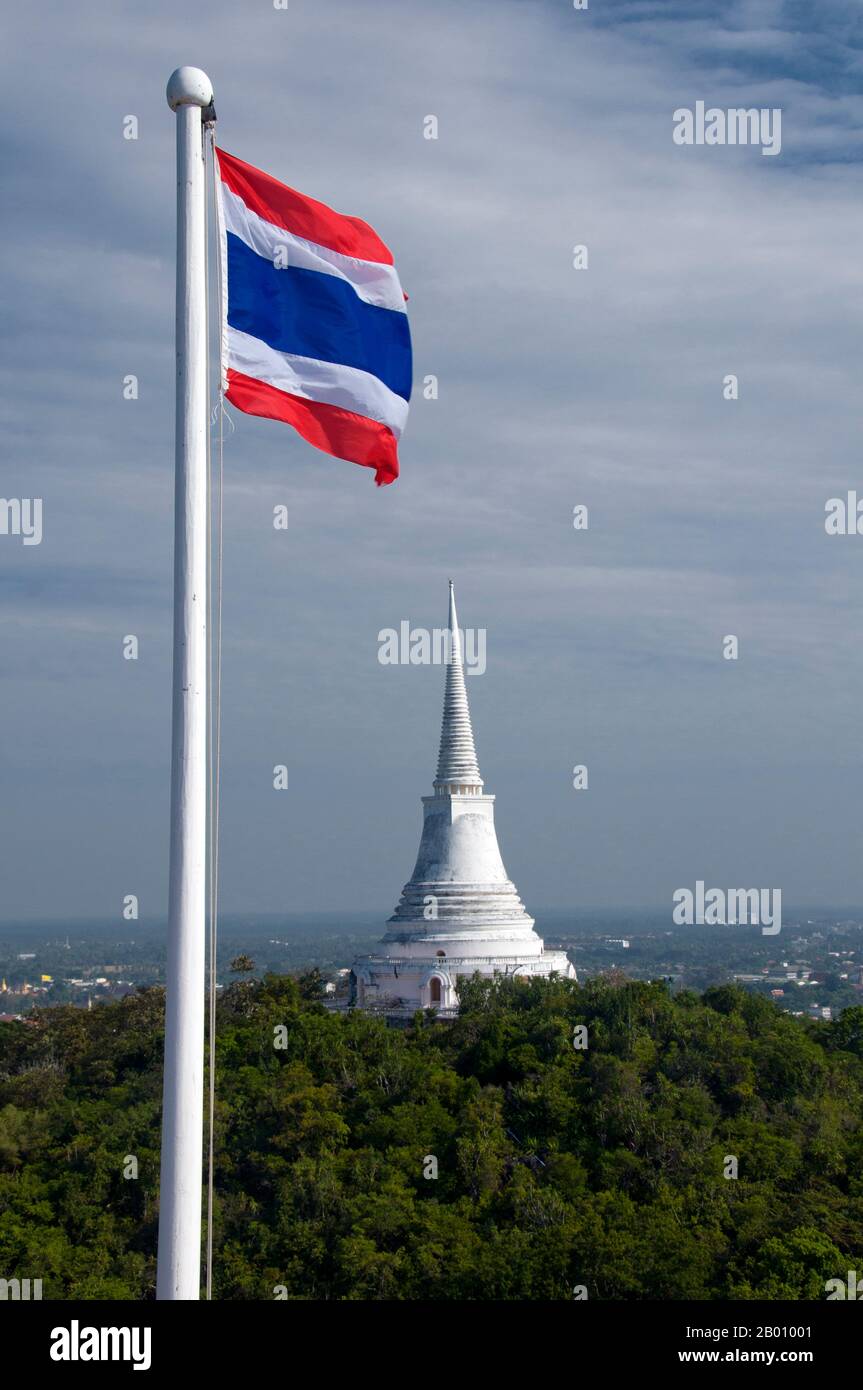Thailand: Weiße Chedi und thailändische Flagge, Khao Wang und Phra Nakhon Khiri Historical Park, Phetchaburi. Phra Nakhon Khiri ist ein historischer Park auf einem Hügel mit Blick auf Phetchaburi Stadt. Der Name Phra Nakhon Khiri bedeutet Hügel der Heiligen Stadt, aber die Einheimischen kennen ihn besser als Khao Wang, was bedeutet Hügel mit Palast. Der ganze Komplex wurde als Sommerpalast von König Mongkut gebaut, die Bauarbeiten wurden 1860 abgeschlossen. Stockfoto