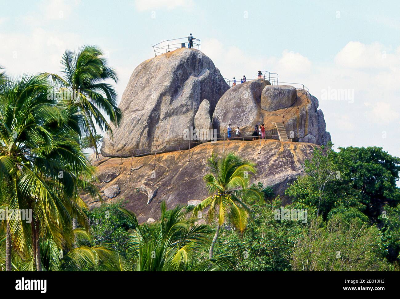 Sri Lanka: Besucher auf der Aradhana Gala (Meditationsfelsen), Mihintale. Mihintale ist ein Berggipfel in der Nähe von Anuradhapura, der von Sri Lankans als Ort einer Begegnung zwischen dem buddhistischen Mönch Mahinda und König Devanampiyatissa geglaubt wird, der die Präsenz des Buddhismus in Sri Lanka einweihte. Es ist jetzt ein Wallfahrtsort und der Ort von mehreren religiösen Denkmälern und verlassenen Strukturen. Stockfoto