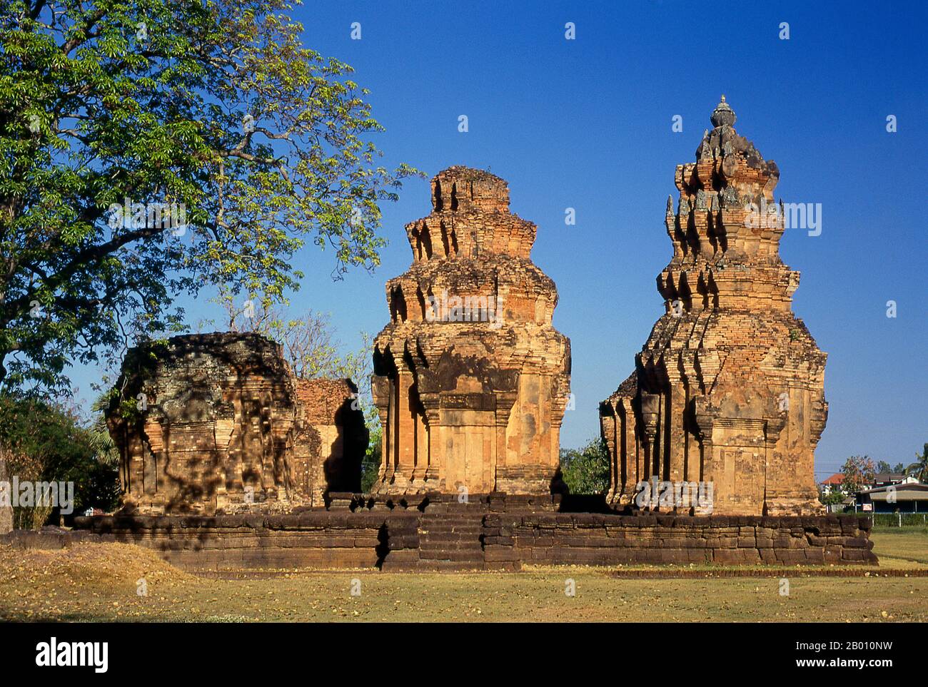 Thailand: Die Ziegelstangen von Prasat Sikhoraphum, Surin Provinz, Nordostthailand. Prasat Sikhoraphum ist ein Khmer Hindu-Tempel, der im 12th. Jahrhundert von König Suryavarman II. (R. 1113 - 1150). Prasat Sikhoraphum stammt aus dem frühen 12th. Jahrhundert und wurde wunderschön restauriert. Es besteht aus fünf Ziegelstangen auf einer quadratischen Lateritplattform, die von mit Lilie gefüllten Teichen umgeben ist. Der Türsturz und die Säulen des zentralen Prangs sind wunderschön mit himmlisch tanzenden Mädchen oder apsara und anderen Szenen aus der hinduistischen Mythologie geschnitzt. Stockfoto