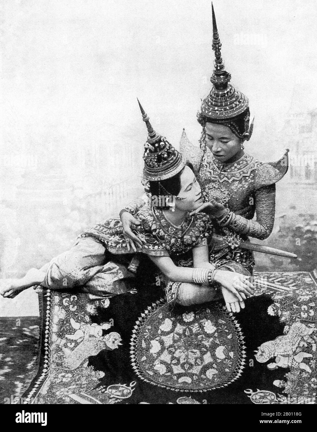 Thailand: Zwei Theaterschauspieler spielen eine Liebesszene aus einem siamesischen Drama, c. 1900. Die Siamesen waren an der Wende des 20. Jahrhunderts begeisterte Theaterbesucher. MIME, Tanz, Theaterstücke und Schattenpuppen waren alle sehr beliebt. Viele der Bühnenstücke waren Tänzerinnen, meist Frauen, die sich in Schmuck schmückten und die Bewegungen zeigten, die Schönheit und Flexibilität darstellten, vor allem beim Biegen der Finger nach hinten. Die gängigsten Stücke wurden ‘khon’ genannt, in denen im Wesentlichen Szenen aus dem ‘Ramakien’, der thailändischen Version des Hindu-Epos ‘The Ramayana’, zu sehen sind. Stockfoto