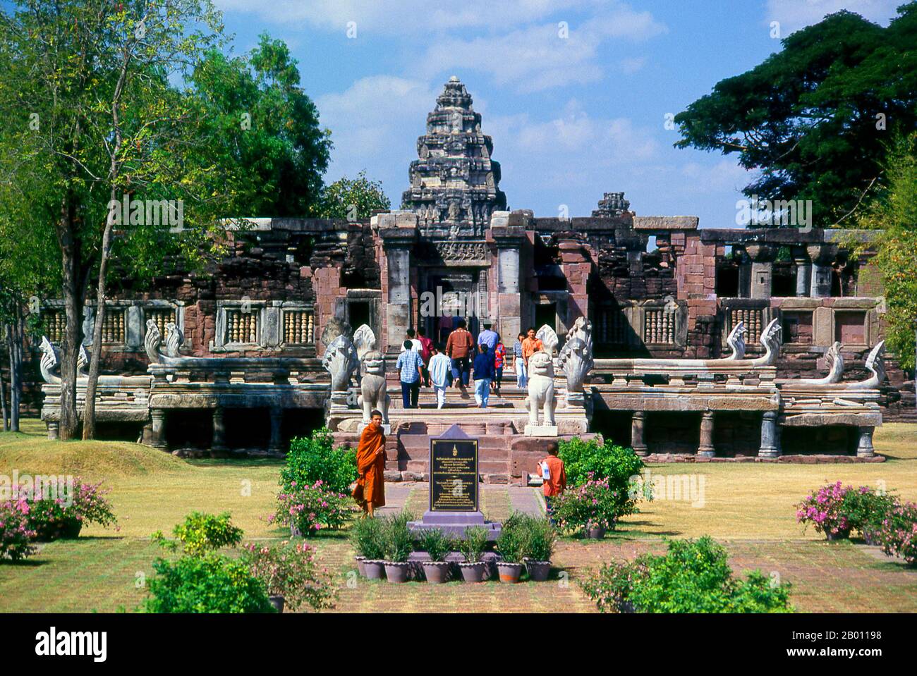 Thailand: Mönch und andere Besucher im Prasat hin Phimai, Historischer Park von Phimai, Provinz Nakhon Ratchasima. Phimai stammt aus dem 11. Und 12. Jahrhundert und war ein wichtiger buddhistischer Tempel und eine Stadt im Khmer-Reich. Der Komplex in Phimai stammt ursprünglich aus der Regierungszeit von Surayavarman II (r. 1113 - 1150), während der ersten Hälfte des 12. Jahrhunderts u.Z. Der Tempel wurde aus weißem, feinkörnigem Sandstein gebaut, im gleichen Stil wie Angkor Wat. Ebenso wie Angkor wurde auch Phimai zunächst dem Vishnu-Kult gewidmet. Der zentrale Turm des Heiligtums stammt aus dieser frühen Periode. Stockfoto