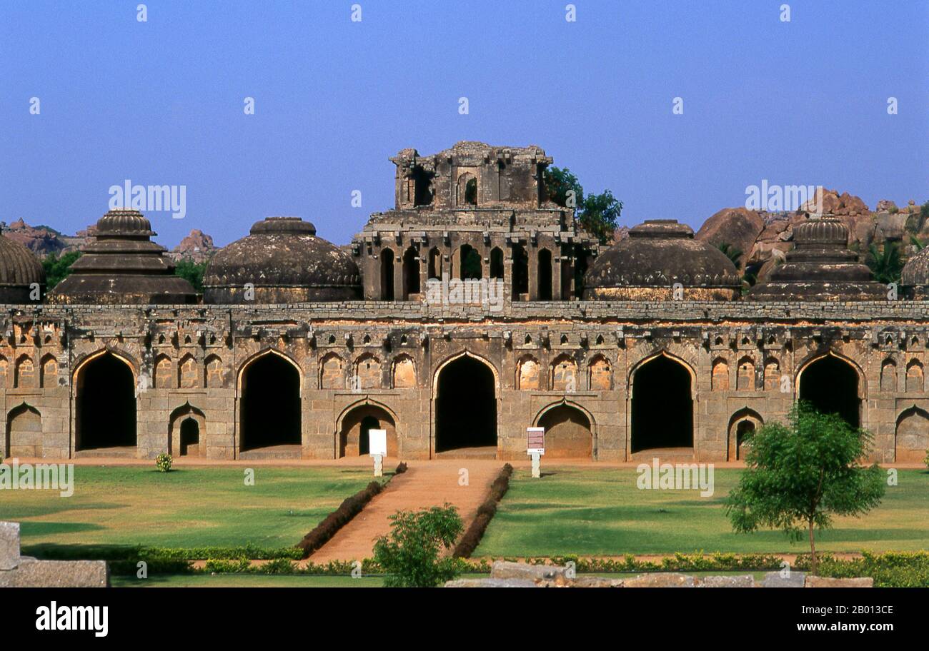 Indien: Elefantenställe, Hampi, Bundesstaat Karnataka. Die Elefantenställe wurden verwendet, um die zeremoniellen Elefanten des königlichen Haushalts zu beherbergen. Die Struktur zeigt einen deutlichen islamischen Einfluss in ihren Kuppeln und gewölbten Toren. Hampi ist ein Dorf im nördlichen Bundesstaat Karnataka. Es befindet sich in den Ruinen von Vijayanagara, der ehemaligen Hauptstadt des Vijayanagara-Reiches. Vor der Stadt Vijayanagara ist es weiterhin ein wichtiges religiöses Zentrum, in dem der Virupaksha-Tempel sowie mehrere andere Denkmäler der Altstadt untergebracht sind. Stockfoto