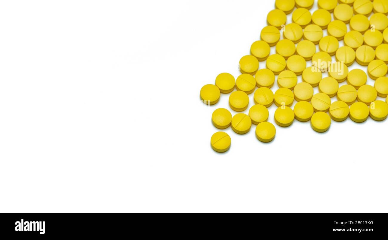 Gelbe kleine runde Tablettenpillen auf weißem Hintergrund. Konzept für das Gesundheitswesen. Schmerzstillende Medikamente. Nichtsteroidale entzündungshemmende Medikamente (NSAIDs). Stockfoto