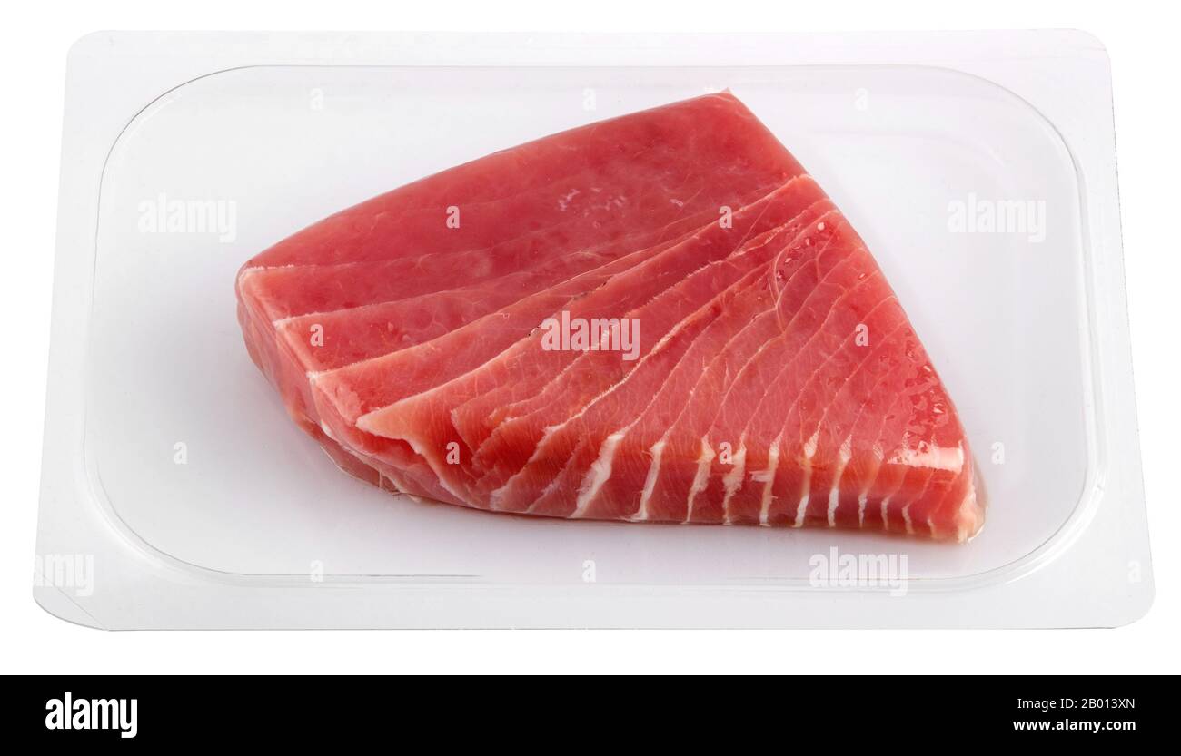 Vakuumverpacktes Thunfisch-Filetstück aus transparentem Kunststoff in Nahaufnahme isoliert auf weißem Hintergrund. Lebensmittelverpackungen zum Schutz der Frische an Stockfoto