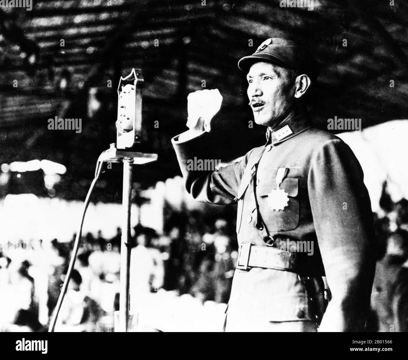 China: General Chiang Kai-shek spricht bei Hankou, 1940. Chiang Kai-shek war ein politischer und militärischer Führer des China des 20. Jahrhunderts. Er ist auf Mandarin als Jiǎng Jièshí oder Jiǎng Zhōngzhèng bekannt. Chiang war ein einflussreiches Mitglied der nationalistischen Partei, der Kuomintang (KMT), und ein enger Verbündeter von Sun Yat-sen. Er wurde Kommandant der Whammoa-Militärakademie der Kuomintang und übernahm den Platz von Sun als Anführer der KMT, als Sun 1925 starb. 1926 führte Chiang die Nordexpedition an, um das Land zu vereinigen. Stockfoto