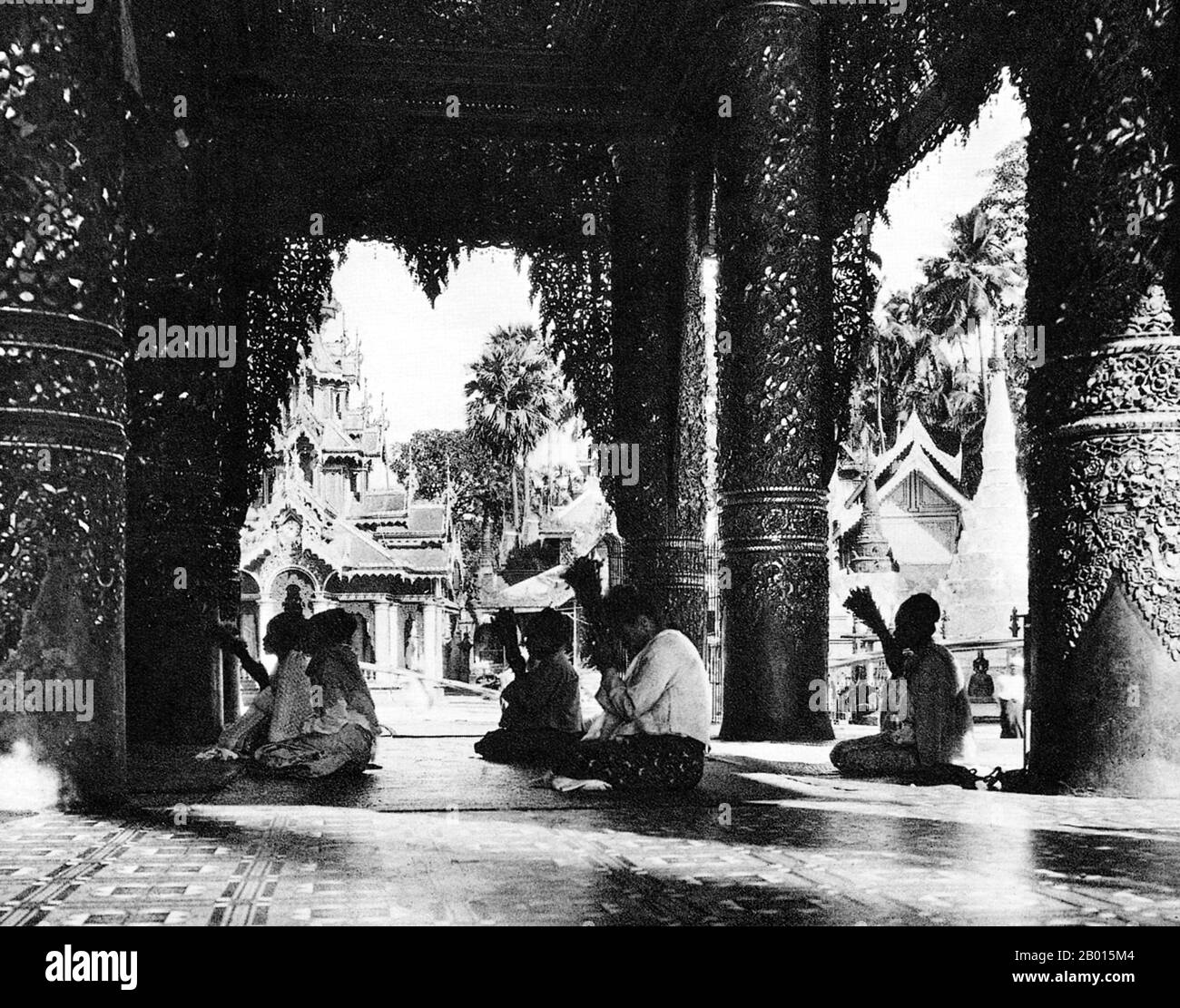 Birma/Myanmar: Buddhisten beten in der Shwedagon Pagode in Rangun, c. 1920er Jahre. Die 98 m (322 ft) lange vergoldete Stupa der Shwedagon-Pagode dominiert die Skyline von Rangun von ihrem Aussichtspunkt auf dem Singuttara-Hügel im Zentrum der Stadt und ist Burmas bekanntestes Wahrzeichen und Buddhistisches Denkmal. Obwohl die Legende besagt, dass die Pagode zur Zeit von Siddharta Gautama, dem Buddha, vor etwa 2,500 Jahren gebaut wurde, schreiben Archäologen den Bau des Tempels den Mon-Leuten irgendwann zwischen dem 6. Und 10. Jahrhundert u.Z. zu. Sie wird oft als die „Goldene Pagode“ bezeichnet. Stockfoto