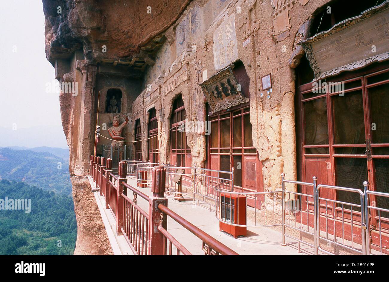 China: Eingeschlossene Höhlen, Maiji Shan Grotten, Tianshui, Provinz Gansu. Maijishan Shiku (Maiji Shan Grotten) sind eine der vier wichtigsten buddhistischen Tempelgruppen Chinas (die anderen sind Datong, Luoyang und die Mogao-Höhlen in Dunhuang). Ausgehend von den Dynastien Nördlicher Wei (386-535) und Nördlicher Zhou (557-81) schnitten Buddhisten Höhlen in die Seiten eines roten Ausschnitts, der aus den umliegenden Laubhügeln aufsteigt. Figuren des Buddha, von Bodhisattvas und Schülern wurden in härtere Felsen gehauen, die von anderswo hergebracht wurden, und in den Höhlen installiert. Stockfoto