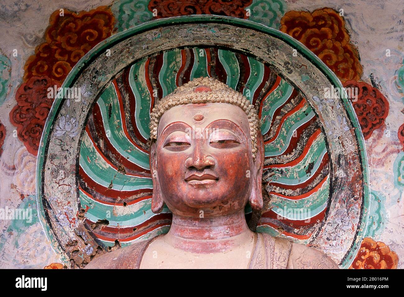 China: Buddha, Maiji Shan Grotten, Tianshui, Provinz Gansu. Maijishan Shiku (Maiji Shan Grotten) sind eine der vier wichtigsten buddhistischen Tempelgruppen Chinas (die anderen sind Datong, Luoyang und die Mogao-Höhlen in Dunhuang). Ausgehend von den Dynastien Nördlicher Wei (386-535) und Nördlicher Zhou (557-81) schnitten Buddhisten Höhlen in die Seiten eines roten Ausschnitts, der aus den umliegenden Laubhügeln aufsteigt. Figuren des Buddha, von Bodhisattvas und Schülern wurden in härtere Felsen gehauen, die von anderswo hergebracht wurden, und in den Höhlen installiert. Stockfoto