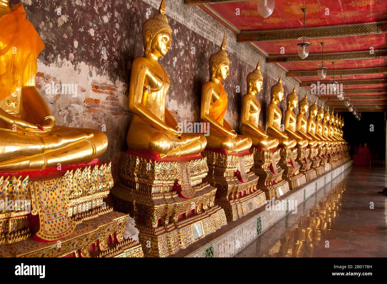 Thailand: Reihe der Buddhas, Wat Suthat, Bangkok. Wat Suthat Thepphawararam ist ein königlicher Tempel der ersten Klasse, einer von sechs solchen Tempeln in Thailand. Der Bau wurde 1807 von König Buddha Yodfa Chulaloke (Rama I) begonnen. Weitere Baumaßnahmen und Dekorationen wurden von König Buddha Loetla Nabhalai (Rama II) durchgeführt, der die Holztüren schnitzen half, aber der Tempel wurde erst unter der Herrschaft von König Jessadabodindra (Rama III) im Jahr 1847 fertiggestellt. Der Tempel ist ein schönes Beispiel des Rattanakosin architektonischen Stils. Es enthält auch das Buddha-Bild Phra Sri Sakyamuni oder „Sisakayamunee“. Stockfoto