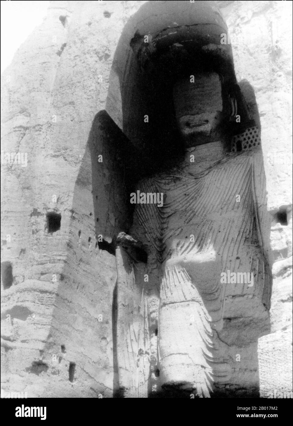 Afghanistan: Der große Buddha in Bamiyan, fotografiert von Robert Byron (26. Februar 1905 - 24. Februar 1941) im Jahr 1934 und zerstört von Taliban-Fanatikern im Jahr 2001. Die Buddhas von Bamiyan waren zwei monumentale Statuen aus dem 6th. Jahrhundert mit stehenden Buddhas, die in die Seite einer Klippe im Bamiyan-Tal in der Region Hazarajat in Zentralafghanistan, 230 km (143 Meilen) nordwestlich von Kabul in einer Höhe von 2.500 m (8.202 Fuß), gehauen wurden. Die Statuen wurden 507 n.Chr. erbaut, die größeren 554 n.Chr., und stellten den klassischen Mischstil der Gandhara-Kunst dar. Die Hauptkörper wurden direkt von den Sandsteinfelsen gehauen. Stockfoto
