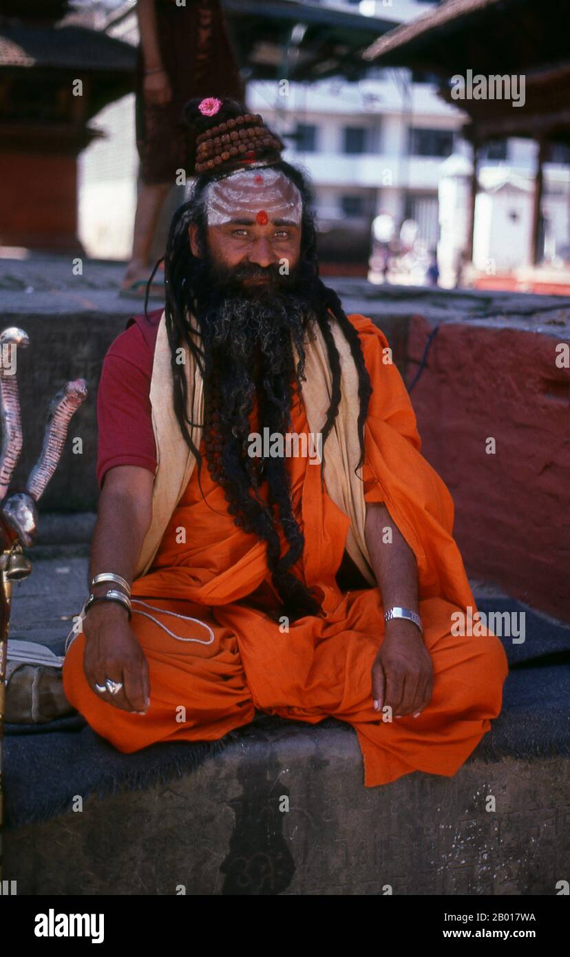 Nepal: Sadhu (Heiliger Mann) auf dem Durbar Square, Kathmandu. Sie sind, verschiedentlich, als Sadhus (Heilige oder 'gute'), Yogis (asketische Praktizierende) bekannt, Fakiren (asketischer Sucher nach der Wahrheit) und Sannyasine (wandernde Bettelmönchen und Asketen). Sie sind die asketischen – und oft exzentrischen – Praktizierenden einer strengen Form des Hinduismus. Geschworen, irdische Wünsche abzuwerfen, entscheiden sich manche dafür, als Anchoriten in der Wildnis zu leben. Andere sind weniger pensioniert, vor allem in den Städten und Tempeln des nepalesischen Kathmandu-Tals. Stockfoto