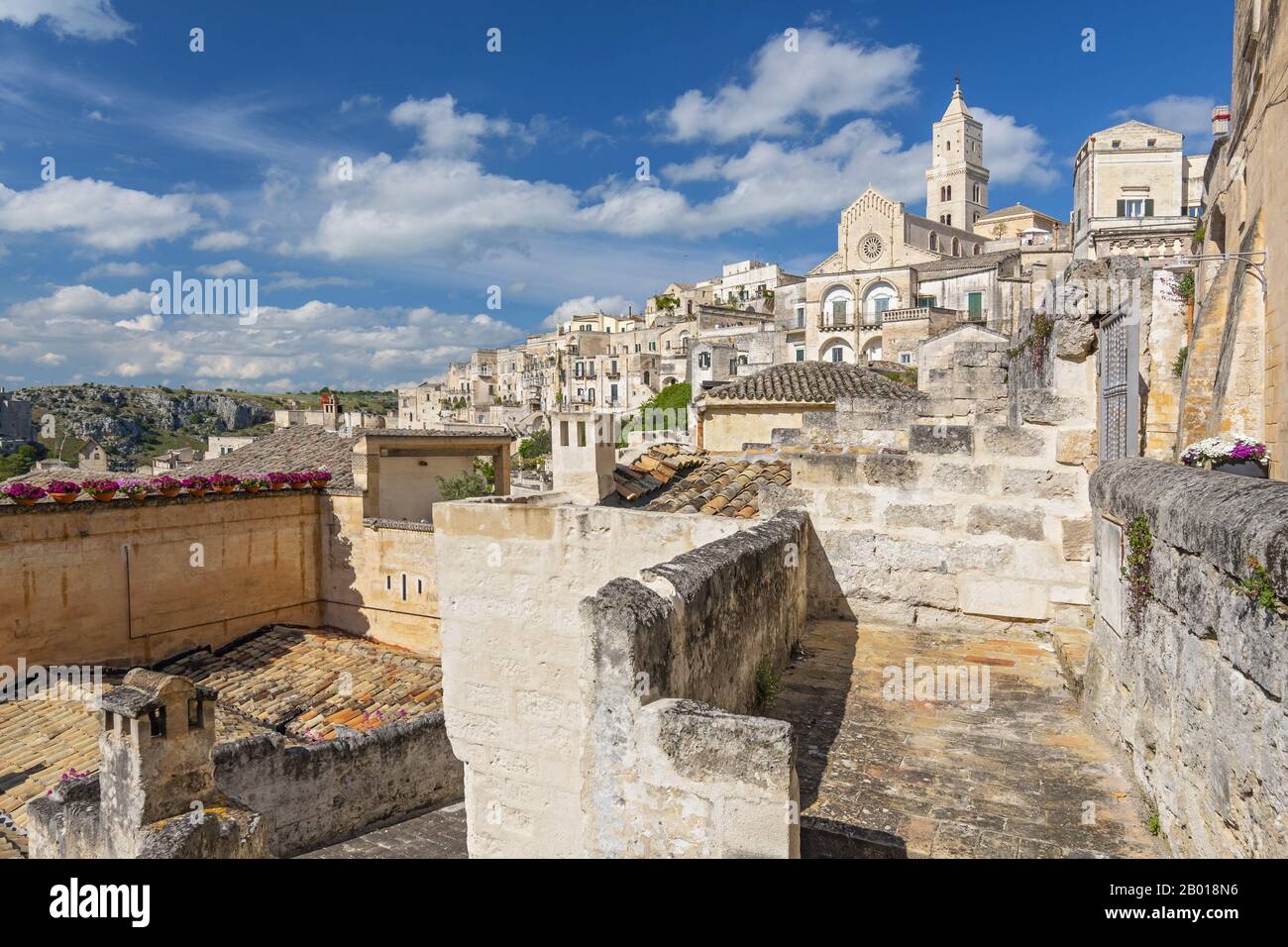 Häuser, die in den Felsen mit der Kathedrale oben auf dem Hügel, in der Höhlenstadt Matera, in der Basilikata Italien, eingebaut sind. Stockfoto