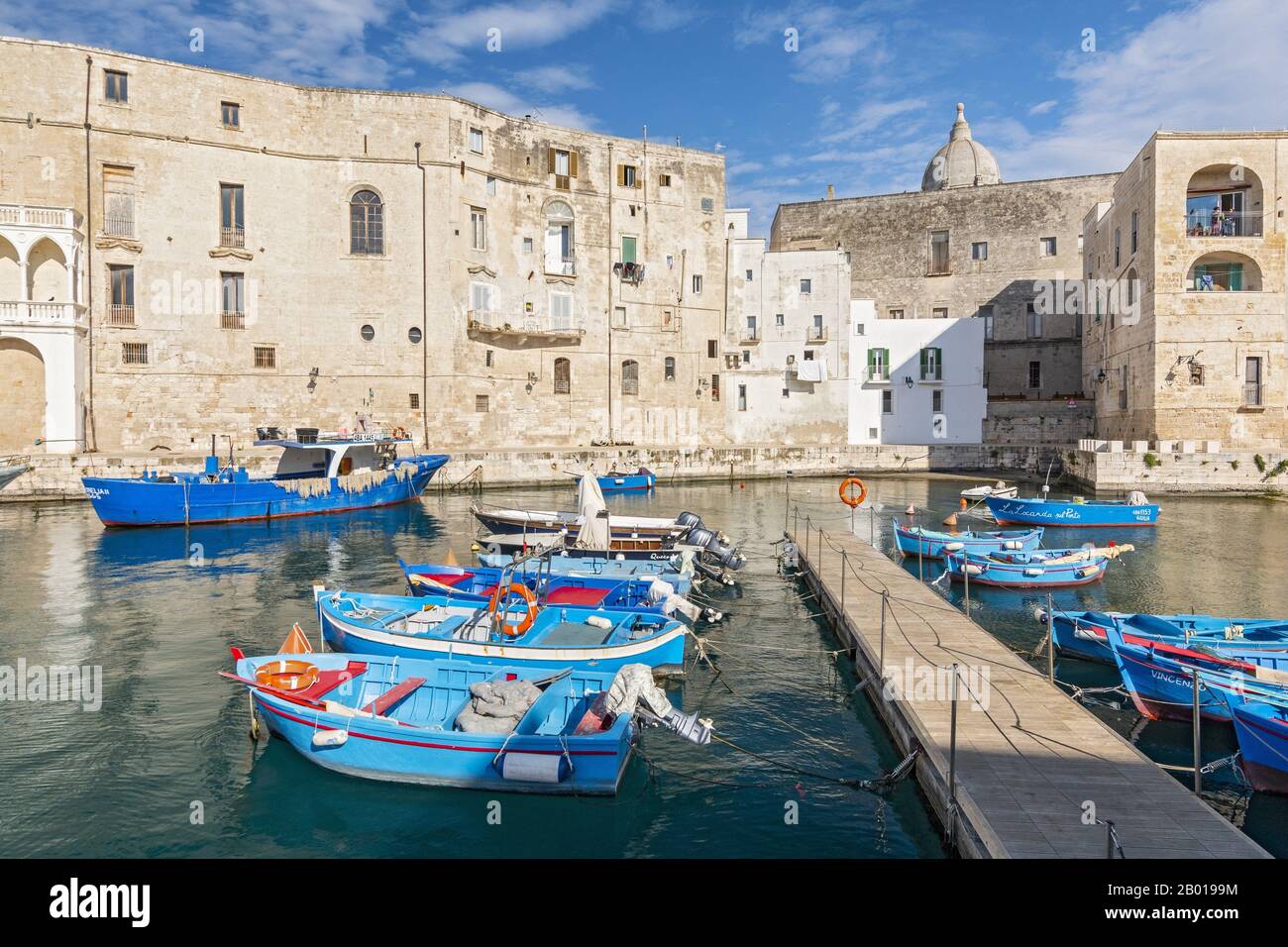 Blick auf den Hafen von Monopoli mit farbenfrohen azurblauen Fischerbooten, Apulien, Italien. Stockfoto