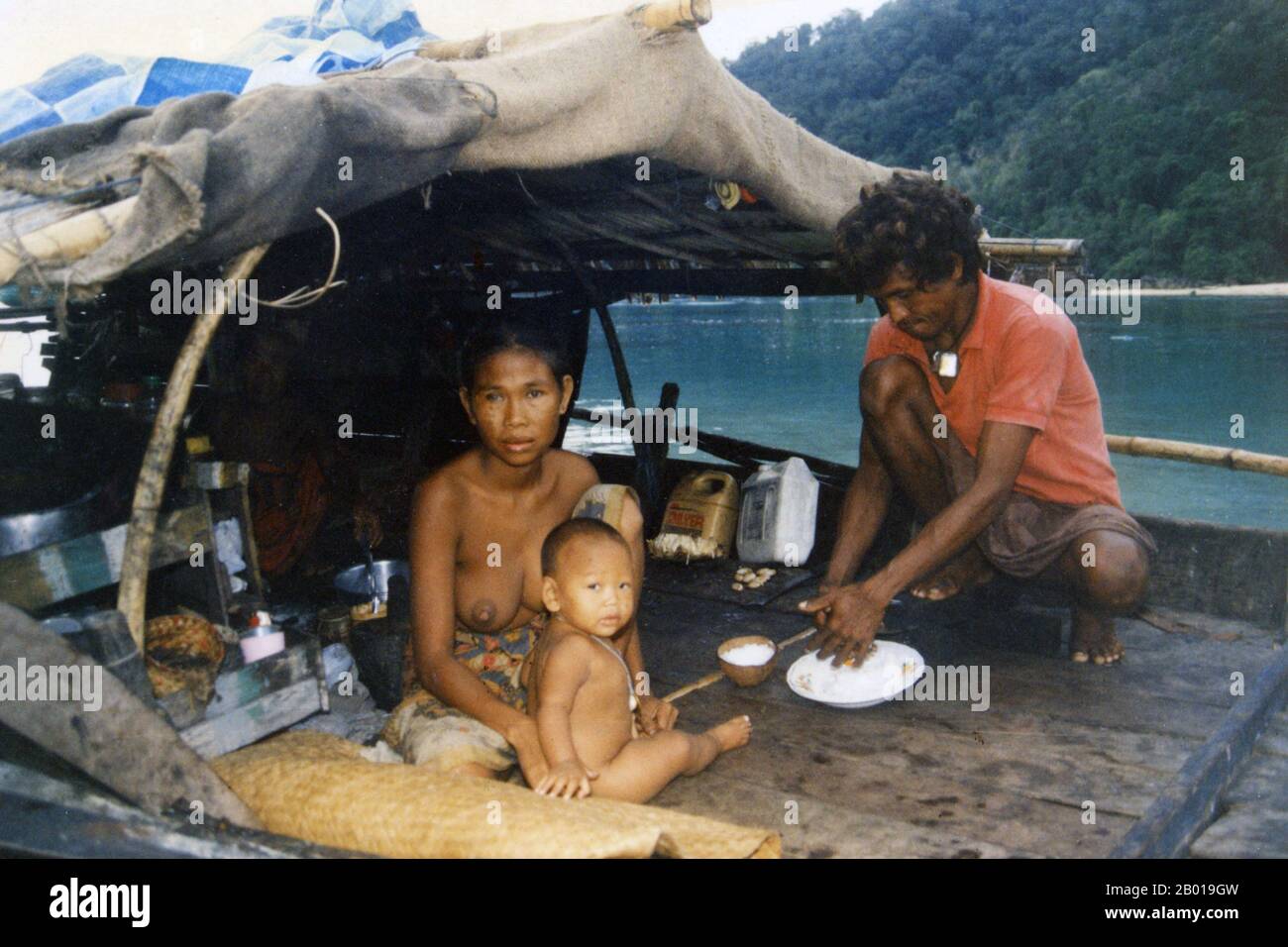 Thailand: Eine Chao Thalae 'Sea Gipsy' Familie, die Essen an Bord ihres Bootes zubereitete, c. 1960. Die ‘Sea Gypsies’ oder Moken der Andamanensee, im Thailändischen als chao thalae oder ‘People of the Sea’ bekannt, werden in drei Gruppen unterteilt. Sie leben zwischen 4.000 und 5.000 Jahren, sie leben nur an der Küste, entweder in Hütten am Ufer oder auf Booten, die die Küstengewässer vom Mergui-Archipel in Burma bis zu den Tarutao-Inseln im Süden Thailands ausfahren. Die größte Sea Gipsy Gruppe sind die Urak Lawoi, die rund 3.000 zählt. Sie leben in einfachen Hütten an Stränden, die sich südlich von Phuket bis zu den Tarutao-Inseln erstrecken. Stockfoto