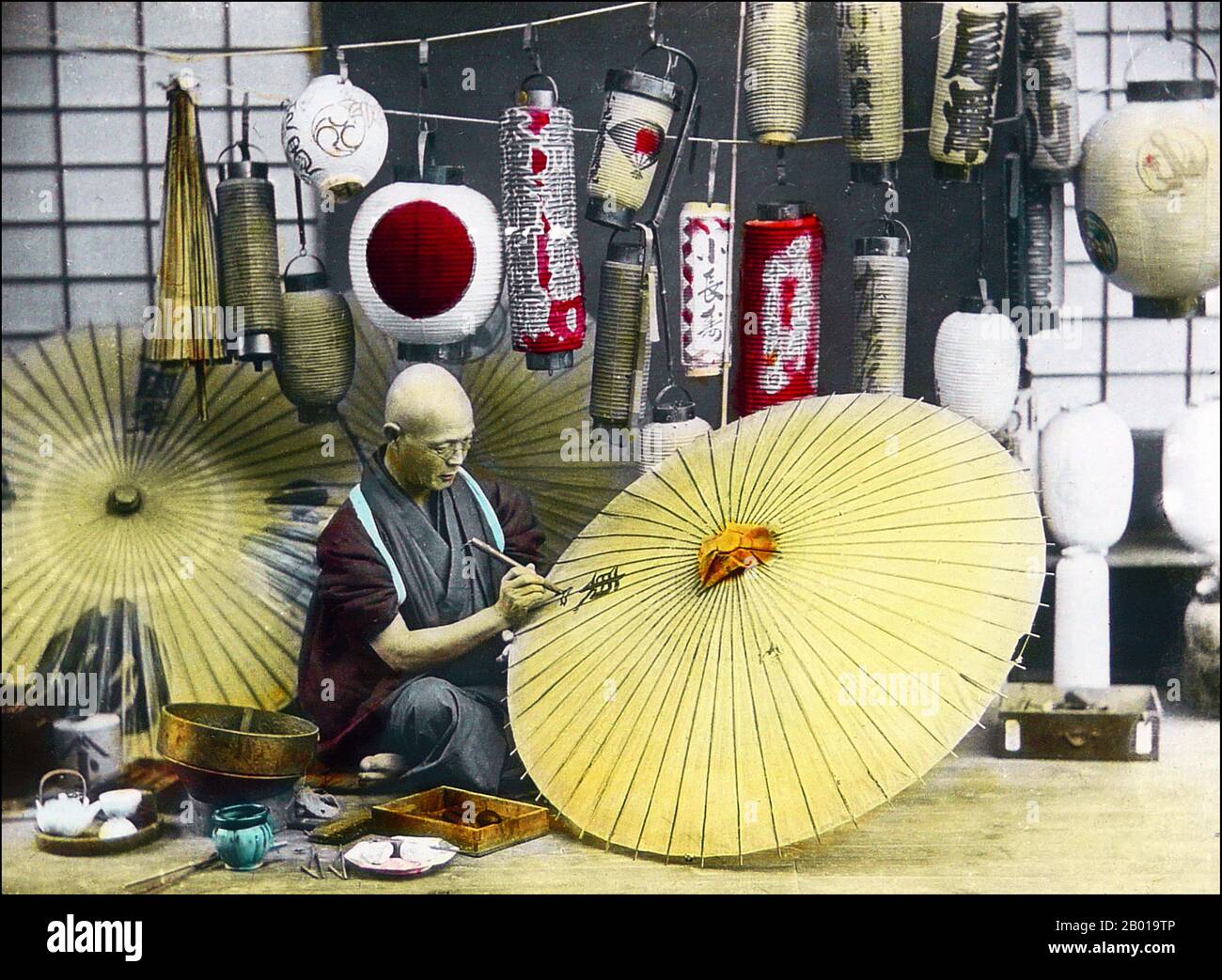Japan: Ein Regenschirmhersteller malt einen Sonnenschirm. Foto von T. Enami (1859-1929), c. 1900-1910. T. Enami (Enami Nobukuni) war der Handelsname eines berühmten Meiji-Fotografen. Der T. seines Handelsnamens soll für Toshi gestanden haben, obwohl er ihn nie auf einem persönlichen oder geschäftlichen Dokument geschrieben hat. Geboren in Edo (heute Tokio) während der Bakumatsu-Ära, war Enami zuerst Schüler und dann Assistent des bekannten Fotografen und Umgangssprache, Ogawa Kazumasa. Enami zog nach Yokohama und eröffnete 1892 ein Studio in der Benten-dōri (Benten Street). Stockfoto