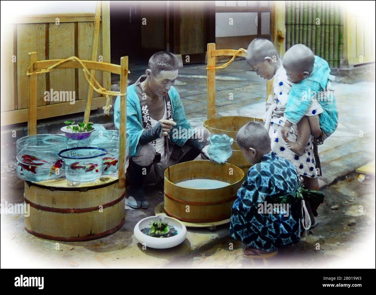 Japan: Kinder mit einem umherziehenden Goldfischverkäufer. Foto von T. Enami (1859-1929), c. 1900. T. Enami (Enami Nobukuni) war der Handelsname eines berühmten Meiji-Fotografen. Der T. seines Handelsnamens soll für Toshi gestanden haben, obwohl er ihn nie auf einem persönlichen oder geschäftlichen Dokument geschrieben hat. Geboren in Edo (heute Tokio) während der Bakumatsu-Ära, war Enami zuerst Schüler und dann Assistent des bekannten Fotografen und Umgangssprache, Ogawa Kazumasa. Enami zog nach Yokohama und eröffnete 1892 ein Studio in der Benten-dōri (Benten Street). Stockfoto