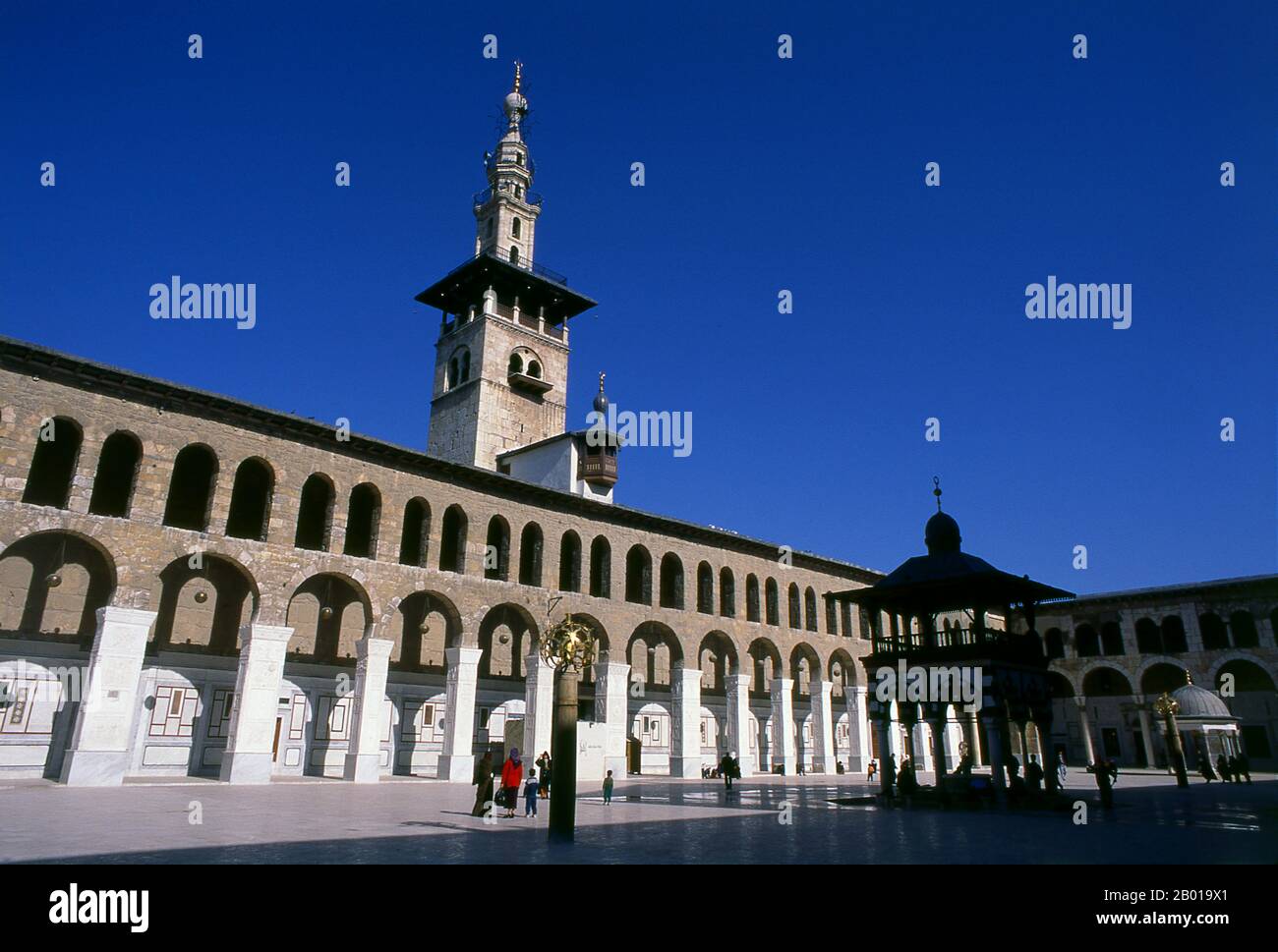 Syrien: Minarett der Braut und der zentrale Innenhof, Umayyad-Moschee, Damaskus. Die Umayyad-Moschee, auch bekannt als die große Moschee von Damaskus, ist eine der größten und ältesten Moscheen der Welt. Es gilt als der viertheiligste Ort im Islam. Der Bau der Moschee soll kurz nach der arabischen Eroberung von Damaskus im Jahr 634 begonnen haben. Die Moschee enthält einen Schrein, der Johannes dem Täufer gewidmet ist, sowie das Grab von Saladin. Stockfoto