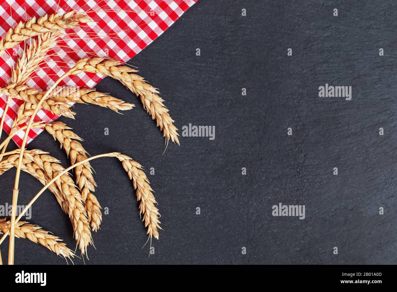 Rote Serviette und Weizen auf blassem Steingrund Stockfoto