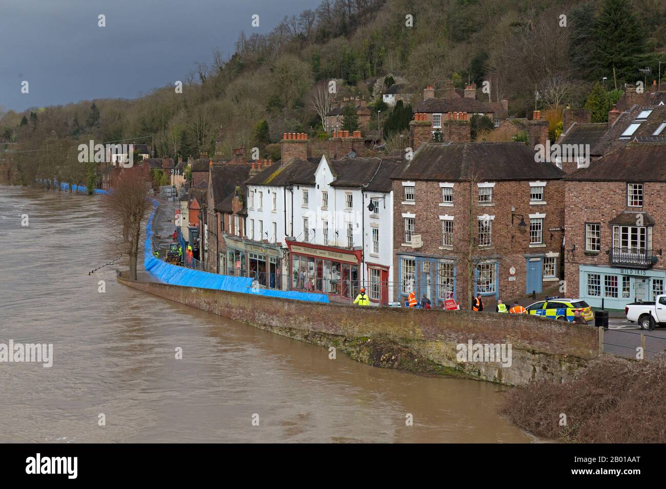 Februar 2020. Der Fluss Severn überschwemmt in Ironbridge, Shropshire, England. Eine temporäre Hochwassersperre kämpft dafür, den Fluss zurückzuhalten, der seit 20 Jahren seinen höchsten Punkt erreicht hat und Häuser und Unternehmen entlang des Flussufern der Ironbridge Gorge bedroht. Die Ironbridge Gorge ist ein Weltkulturerbe. Stockfoto