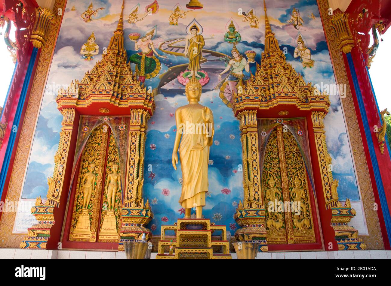 Thailand: Buddha-Statue und Wandmalereien auf dem Viharn im Wat Phra Nang Sang, Phuket. Wat Phra Nang Sang wurde im 19.. Jahrhundert von einer einheimischen Dame guter Familie gegründet, daher der Name phra nang sang, was soviel bedeutet wie ‘erbaut von der verehrten Dame’. Ihr richtiger Name scheint vergessen worden zu sein. Nach lokalen Überlieferungen reiste sie auf einer Pilgerreise nach Sri Lanka und, um sich für ihre sichere Rückkehr zu bedanken, unterstützte sie den Bau dieses Tempels. Später wurde sie von einem lokalen Herrscher verfault, der ihr den Kopf abschneiden ließ, nur um festzustellen, dass ihr Blut vor Reinheit weiß floss. Stockfoto