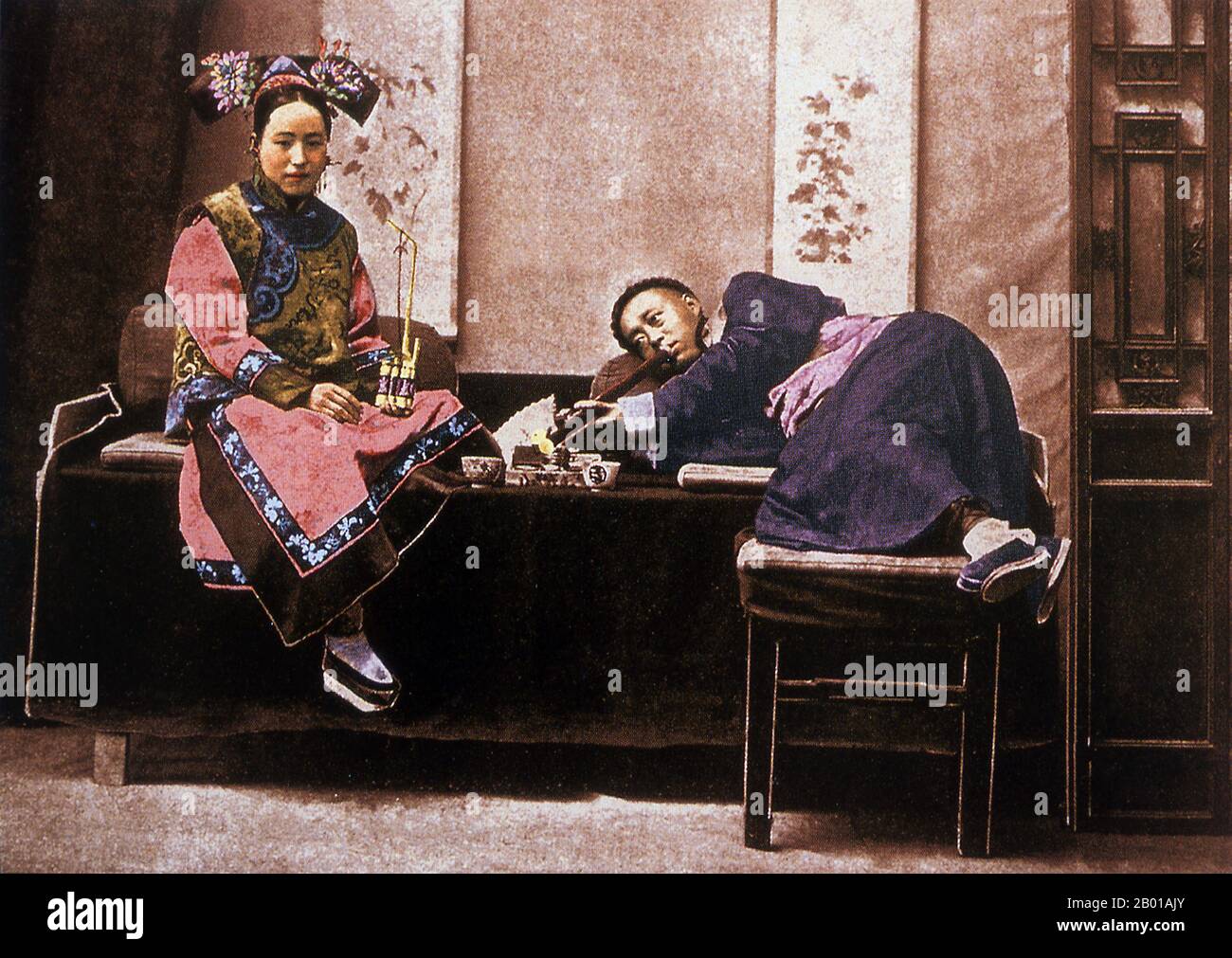 China: Ein posierte Bild eines mandschu-Mannes und einer Frau, die Opium rauchen, späte Qing-Dynastie, c. 1890. Opium (Mohn-Tränen, Lachryma papaveris) ist das getrocknete Latex, das aus dem Opiummohn (Papaver somniferum) gewonnen wird. Opium enthält bis zu 12 Prozent Morphin, ein Alkaloid, das häufig chemisch zu Heroin für den illegalen Drogenhandel verarbeitet wird. Das Latex enthält auch Codein und nicht-narkotische Alkaloide wie Papaverin, Thebain und Noscapin. Die traditionelle Methode zur Gewinnung des Latexs besteht darin, die unreifen Samenschoten (Früchte) von Hand zu kratzen (zu „zerkratzen“). Stockfoto