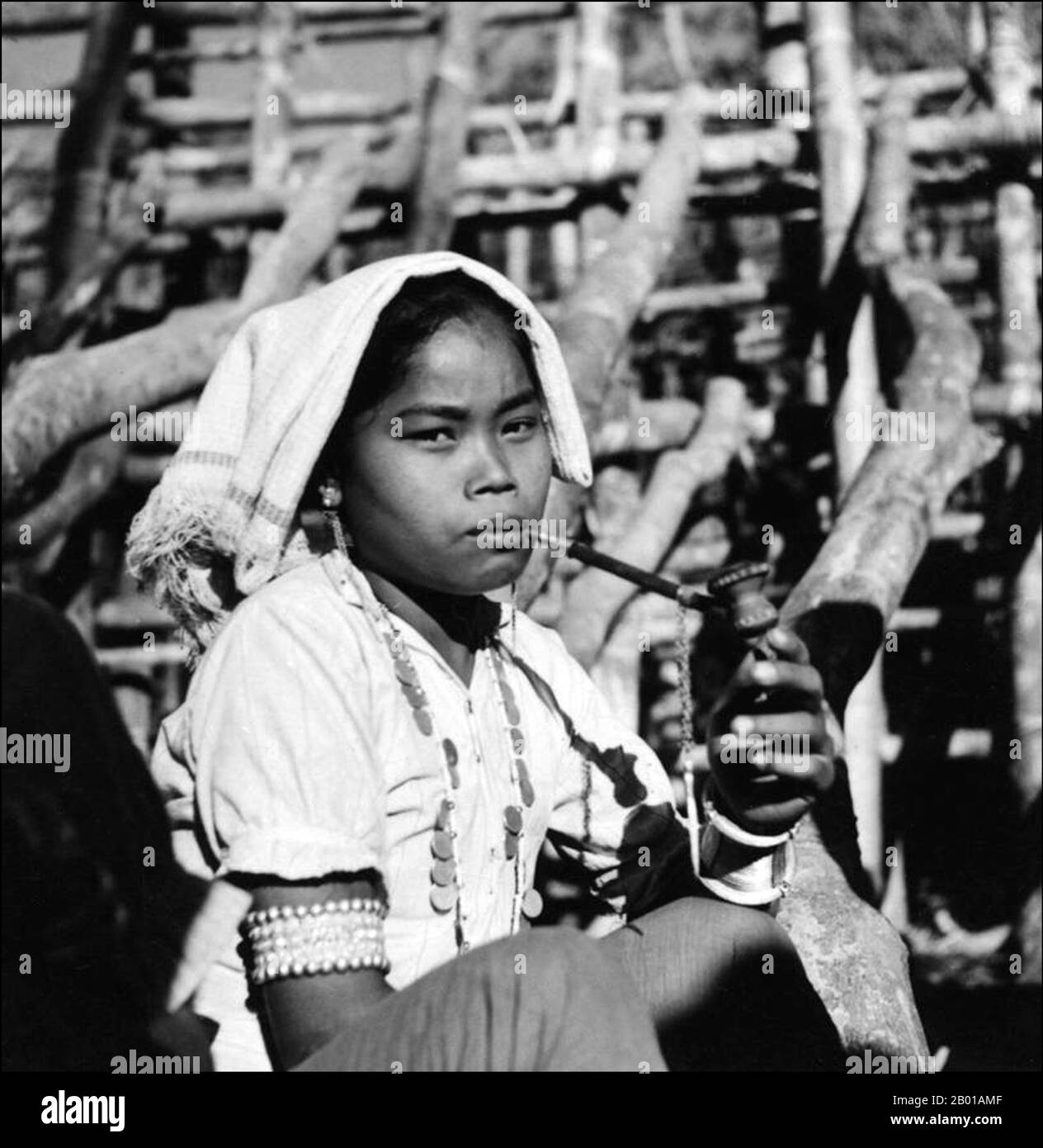 Bangladesch: Eine junge Marma Frau raucht eine Pfeife, c. 1947. Die Marma, auch als Magh oder Mog bekannt, sind Arakanesen, die seit der Arakan-Königsperiode im 16.. Jahrhundert n. Chr. die Chittagong Hill Tracts von Bangladesch bewohnen. Ende des 20.. Jahrhunderts lag ihre Bevölkerung bei über 210.000. Ethnisch mit den Burmesen verwandt, sind sie weitgehend Anhänger des Theravada-Buddhismus. Sie sind die zweitgrößte ethnische Minderheit in Bangladesch. Die meisten Marmas leben in den drei Hügelvierteln Rangamati, Bandarban und Khagrachhari. Stockfoto