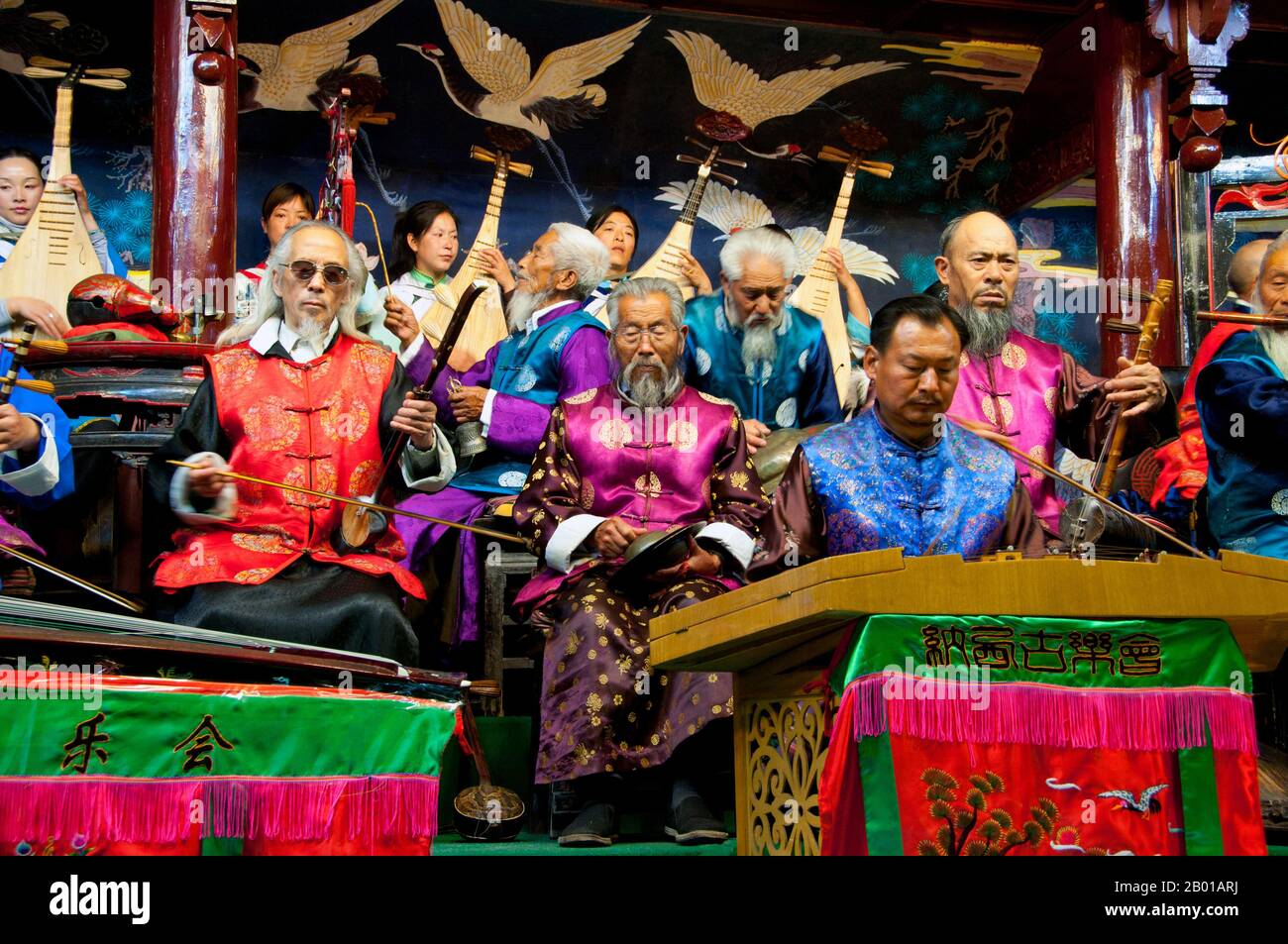 China: Das Naxi (Nakhi) Folk Orchestra, Naxi Orchestra Hall, Lijiang Old Town, Provinz Yunnan. Naxi-Musik ist 500 Jahre alt und hat mit ihrer Mischung aus literarischen Texten, poetischen Themen und musikalischen Stilen der Tang-, Song- und Yuan-Dynastien sowie einigen tibetischen Einflüssen einen eigenen, einzigartigen Stil und Züge entwickelt. Es gibt drei Hauptstile: Baisha, Dongjing und Huangjing, alle mit traditionellen chinesischen Instrumenten. Die Naxi oder Nakhi sind eine ethnische Gruppe, die am Fuße des Himalaya im Nordwesten der Provinz Yunnan lebt. Stockfoto
