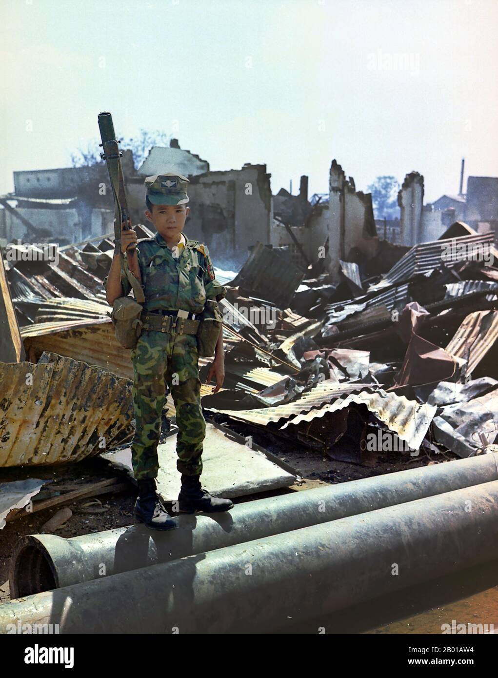 Vietnam: Ein zwölfjähriger Kindersoldat in der Uniform der Armee der Republik Vietnam (ARVN), Tan Son Nhut Airport, Saigon, 7. Mai 1968. Ein zwölfjähriger vietnamesischer ARVN Airborne-Trooper, der von der Airborne Division "adoptiert" worden war und einen M-79-Granatwerfer im Besitz hatte. Das Bild wurde während eines Sweeps einer Airborne Task Force Unit durch das verwüstete Gebiet rund um den französischen Nationalfriedhof auf der Plantation Road nach einem Tag langen Kampf dort aufgenommen. Stockfoto