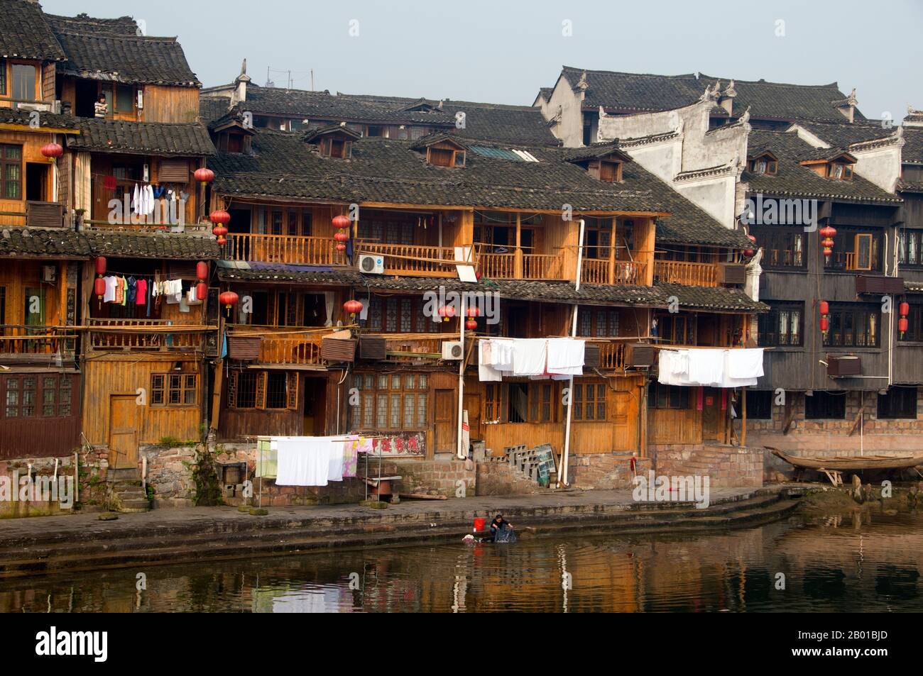 China: Alte Holzhäuser am Ufer des Flusses Tuo, Fenghuang, Provinz Hunan. Fenghuang ist Chinesisch für Phoenix und bezieht sich auf den mythischen heiligen feuervogel, der in den Mythologien der Peter, Griechen, Römer, Ägypter, Chinesen, Und (nach Sanchuniathon) die Phönizier. Die Legende besagt, dass zwei Phönixe, die die Stadt entdeckten, einige Zeit über dem Kopf schwebten, bevor sie widerwillig wegflogen. Die Stadt Fenghuang ist eine gut erhaltene antike Stadt, die angeblich aus dem Jahr 248 v. Chr. stammt. Hier leben die Minderheiten Miao und Tujia. Stockfoto