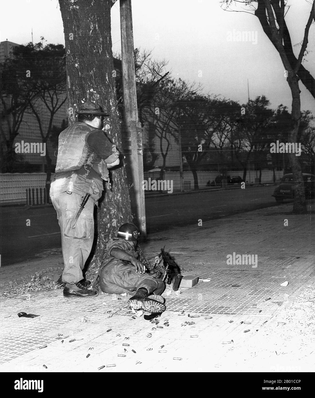 Vietnam: MILITÄRPOLIZEI DER US-Armee deckt sich vor der US-Botschaft, Saigon, am Thong Nhut Boulevard - Tet Offensive, 31. Januar 1968. Kurz nach Mitternacht am 31. Januar 1968 versammelten sich 19 Vietcong-Absapper des Elite-Bataillons C-10 Sapper in einem Vietcong-Sicherheitshaus in einer Autowerkstatt in der Phan Thanh Gian Straße 59, um Waffen zu verteilen und die letzten Vorbereitungen für den Angriff zu treffen. Um 02:47 Uhr blies der Vietcong ein kleines Loch in die Umfassungsmauer am Thong Nhut Boulevard und erhielt Zugang zum Botschaftsgelände. Stockfoto
