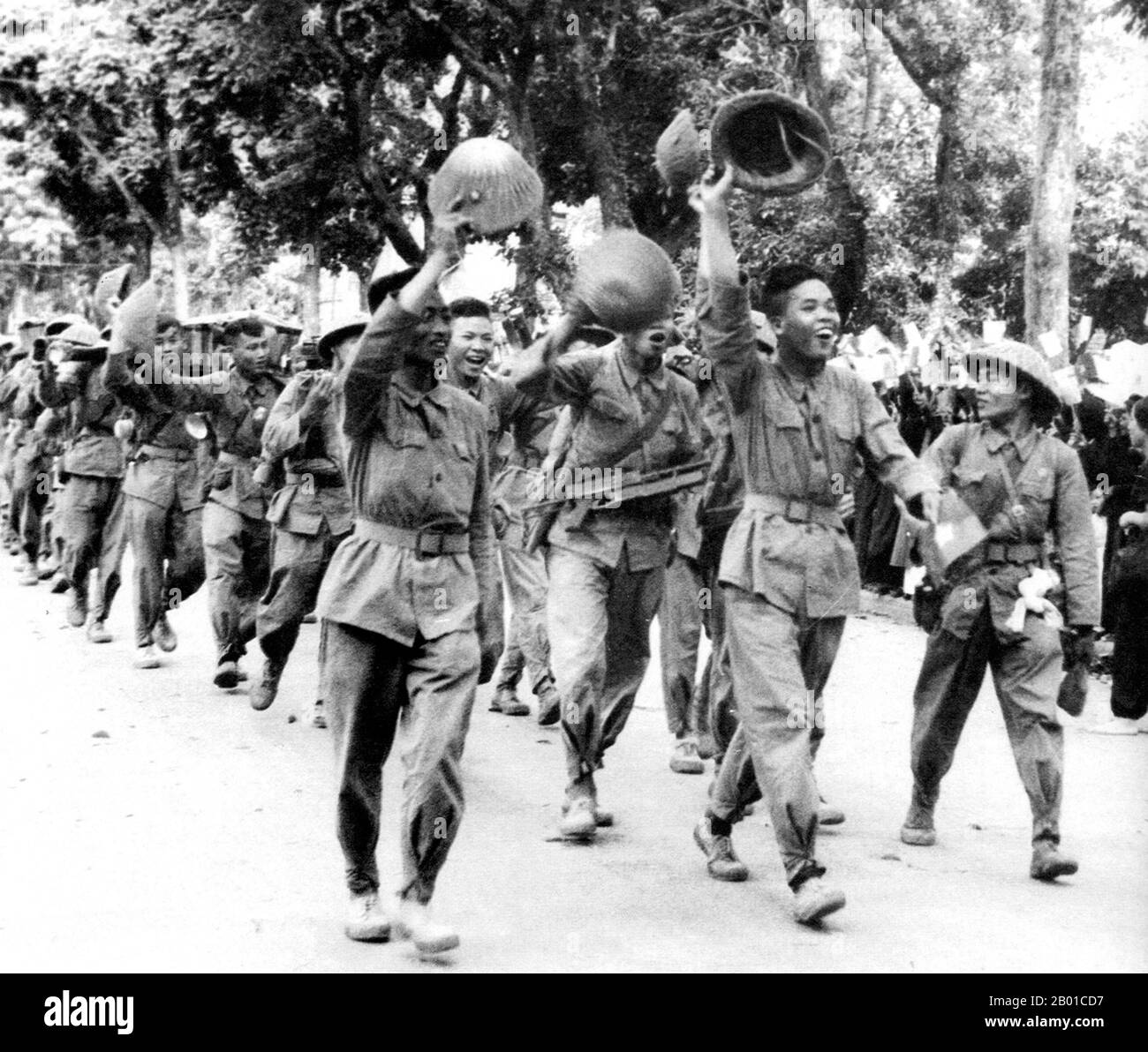 Vietnam: Die fröhlichen Viet Minh-Truppen winken der Bevölkerung der Stadt zu und genießen eine Siegesparade durch die Straßen von Hanoi, 9. Oktober 1954. Der erste Indochinakrieg (auch bekannt als französischer Indochinakrieg, antifranzösischer Krieg, französisch-vietnamesischer Krieg, französisch-vietnamesischer Krieg, Indochinakrieg, Schmutziger Krieg in Frankreich und antifranzösischer Widerstandskrieg im heutigen Vietnam) wurde in Französisch-Indochina vom 19. Dezember 1946 bis zum 1. August 1954 geführt. Der Krieg fand zwischen dem französischen Fernost-Expeditionskorps der Französischen Union und den Việt Minh unter der Führung von Hồ Chí Minh und Võ Nguyên Giáp statt. Stockfoto