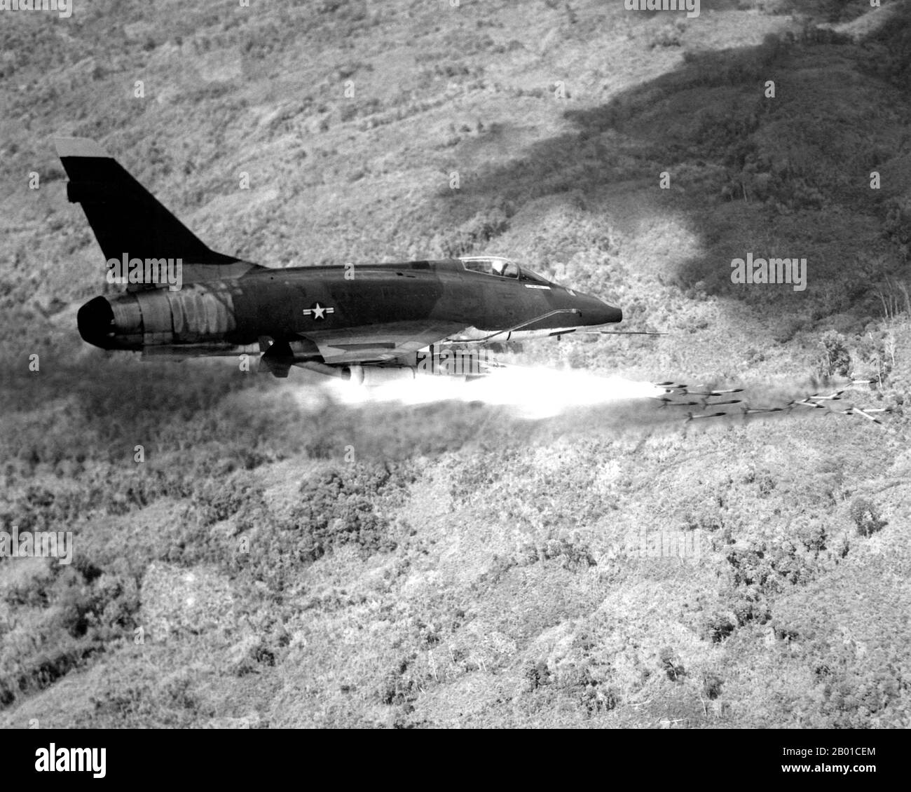 Vietnam: Ein Flugzeug der Air Force F-100D Super Sabre feuert eine Salve von 2,75-Zoll-Raketen auf eine feindliche Position in Südvietnam, 1967. Das Flugzeug lieferte einen Großteil der taktischen Luftunterstützung für alliierte Bodentruppen, die in Vietnam kämpfen. Der zweite Indochina-Krieg, in Amerika als Vietnamkrieg bekannt, war ein militärischer Konflikt aus der Zeit des Kalten Krieges, der sich in Vietnam, Laos und Kambodscha vom 1. November 1955 bis zum Fall Saigons am 30. April 1975 ereignete. Dieser Krieg folgte auf den ersten Indochina-Krieg und wurde zwischen Nordvietnam, unterstützt von seinen kommunistischen Verbündeten, und der Regierung von Südvietnam geführt. Stockfoto