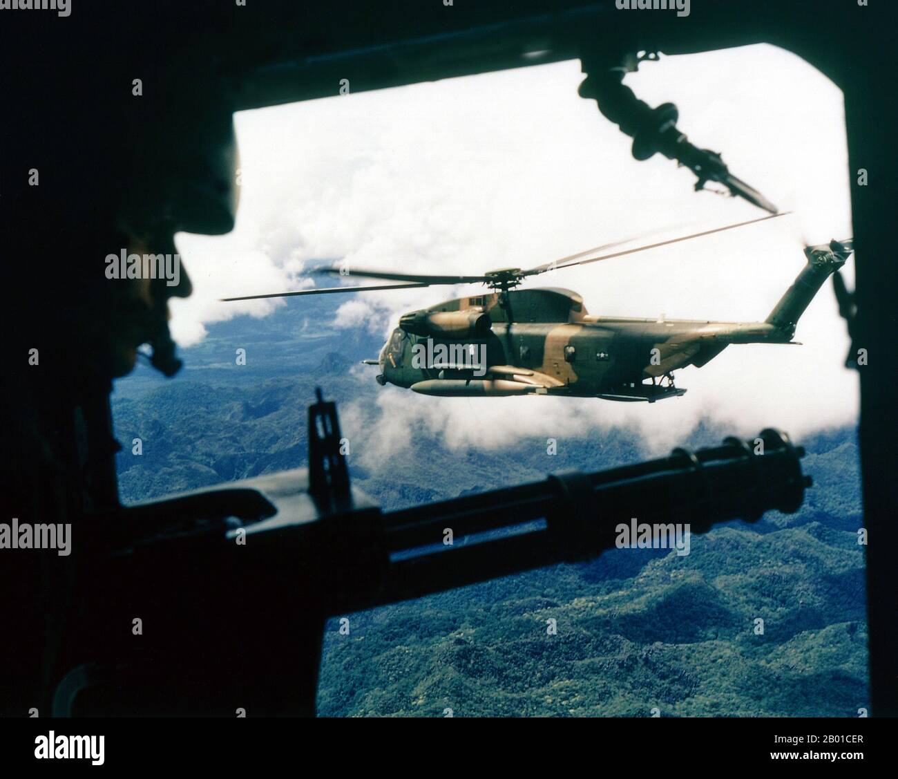 Vietnam: Ein Hubschrauber der US-Luftwaffe Sikorsky HH-53 Super Jolly Green Giant aus der Position des Schützen in einem Hubschrauber des 21. Special Operations Squadron, Vietnam. Foto von Ken Hackman (öffentlich zugänglich), Oktober 1972. Der zweite Indochina-Krieg, in Amerika als Vietnamkrieg bekannt, war ein militärischer Konflikt aus der Zeit des Kalten Krieges, der sich in Vietnam, Laos und Kambodscha vom 1. November 1955 bis zum Fall Saigons am 30. April 1975 ereignete. Dieser Krieg folgte dem ersten Indochina-Krieg und wurde zwischen Nord-Vietnam und der Regierung von Süd-Vietnam, unterstützt von den Vereinigten Staaten, geführt. Stockfoto