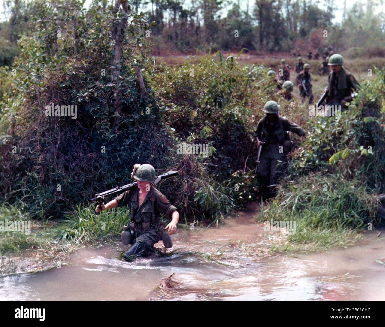 Vietnam: Soldaten der US Army 1. Infantry Division tragen ein M-60 Maschinengewehr über einen Strom, 1968. Der zweite Indochina-Krieg, in Amerika als Vietnamkrieg bekannt, war ein militärischer Konflikt aus der Zeit des Kalten Krieges, der sich in Vietnam, Laos und Kambodscha vom 1. November 1955 bis zum Fall Saigons am 30. April 1975 ereignete. Dieser Krieg folgte dem ersten Indochina-Krieg und wurde zwischen Nordvietnam, unterstützt von seinen kommunistischen Verbündeten, und der Regierung von Südvietnam, unterstützt von den USA und anderen antikommunistischen Nationen, geführt. Stockfoto