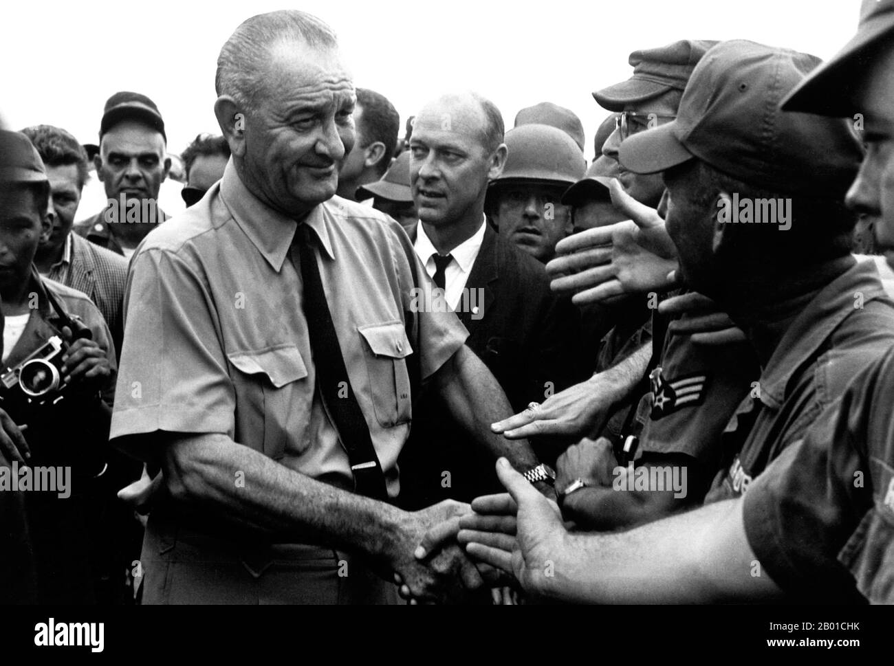 Vietnam: Präsident Lyndon B. Johnson begrüßt amerikanische Truppen in Saigon, 1966. Der zweite Indochina-Krieg, in Amerika als Vietnamkrieg bekannt, war ein militärischer Konflikt aus der Zeit des Kalten Krieges, der sich in Vietnam, Laos und Kambodscha vom 1. November 1955 bis zum Fall Saigons am 30. April 1975 ereignete. Dieser Krieg folgte dem ersten Indochina-Krieg und wurde zwischen Nordvietnam, unterstützt von seinen kommunistischen Verbündeten, und der Regierung von Südvietnam, unterstützt von den USA und anderen antikommunistischen Nationen, geführt. Die US-Regierung betrachtete die Beteiligung am Krieg als eine Möglichkeit, eine kommunistische Übernahme von Südvietnam zu verhindern. Stockfoto