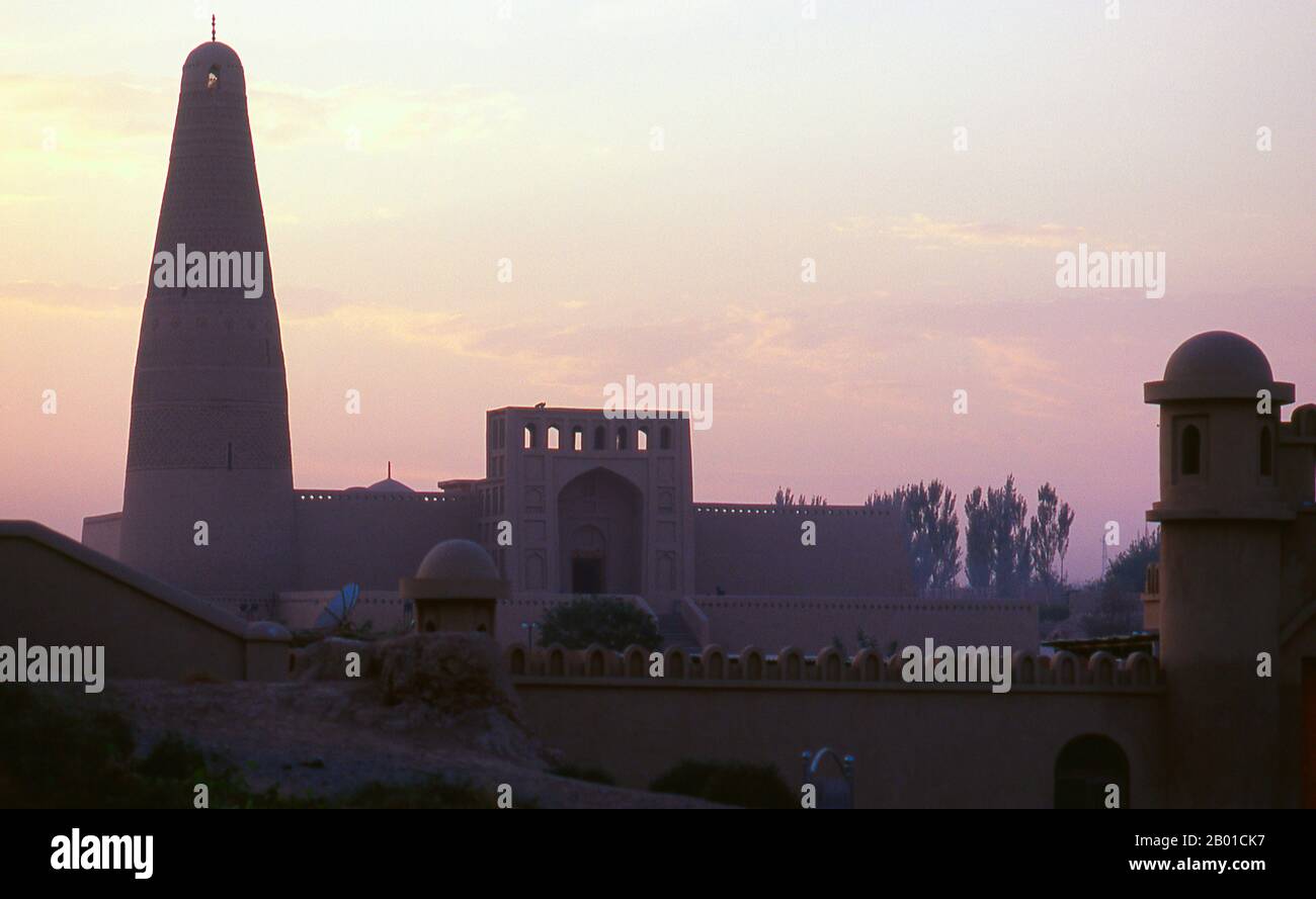 China: Emin Minarett und Moschee in der Abenddämmerung, Turpan, Provinz Xinjiang. Das Emin Minarett oder Imin Ta ist 44 Meter (144 ft) hoch und das höchste Minarett in China. Das Minarett wurde 1777 unter der Herrschaft des Qing-Imperators Qianlong (1735–1796) gegründet und nur ein Jahr später fertiggestellt. Es wurde von lokalen Führern finanziert und gebaut, um die Heldentaten eines lokalen Turpan-Generals, Emin Khoja, zu ehren, daher der Name "Emin". Die Oase Turpan war ein strategisch bedeutendes Zentrum an der nördlichen Seidenstraße von Xinjiang, wo sich die alten Städte Yarkhoto (Jiaohe) und Karakhoja (Gaochang) befinden. Stockfoto