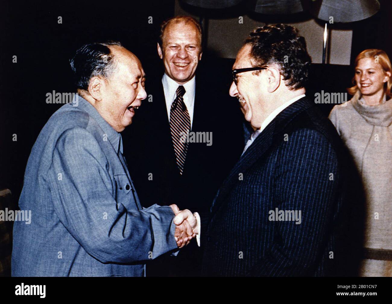 China/USA: Vorsitzender Mao Zedong schüttelt sich als Präsident Henry Kissinger die Hände Gerald Ford und seine Tochter Susan Ford Look On, Peking, 2. Dezember 1975 Kissinger diente als nationaler Sicherheitsberater und später gleichzeitig als Staatssekretär in den Verwaltungen der Präsidenten Richard Nixon und Gerald Ford. Nach seiner Amtszeit wurde seine Meinung immer noch von vielen folgenden Präsidenten und führenden Politikern der Welt gesucht. Kissinger, ein Befürworter der Realpolitik, spielte zwischen 1969 und 1977 eine dominierende Rolle in der US-Außenpolitik. In dieser Zeit war er Vorreiter bei der Entspannungspolitik mit der Sowjetunion. Stockfoto